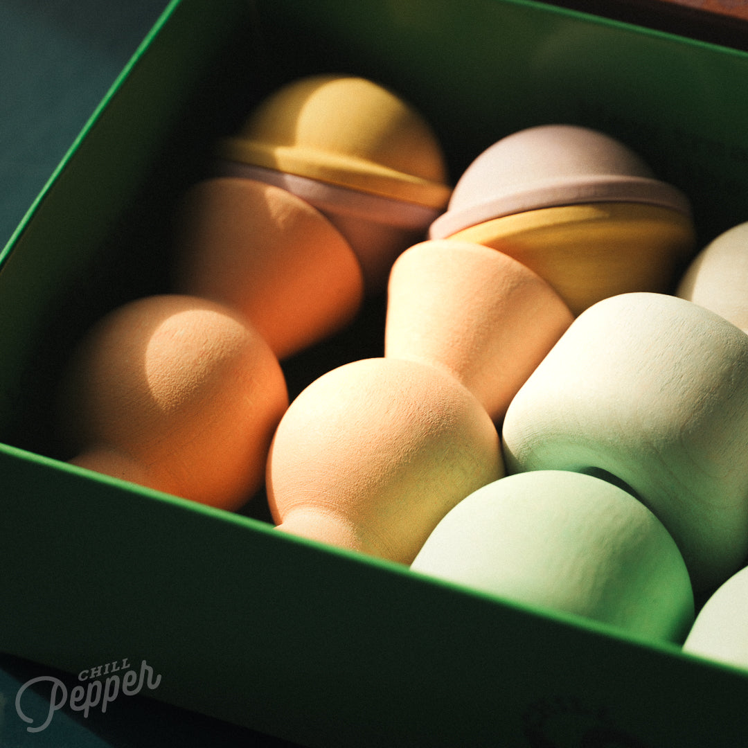 Wooden Chill Pepper Treats stacking and spinning game for ages 3 and up, made from eco-friendly maple wood and non-toxic, water-based paints. The set includes a variety of pastel-colored candy-shaped pieces and a unique Magic Egg for open-ended play.