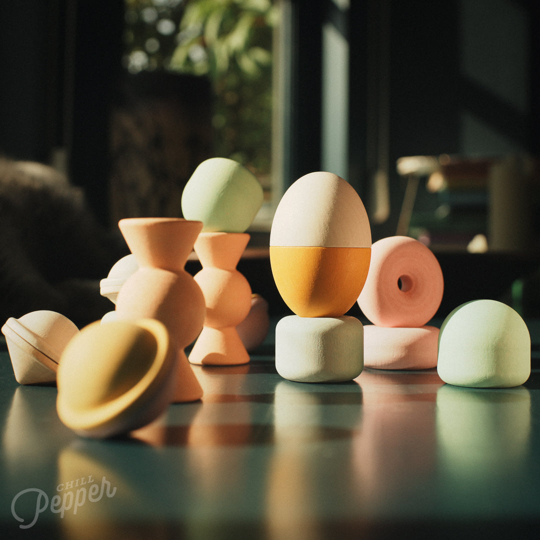 Wooden Chill Pepper Treats stacking and spinning game for ages 3 and up, made from eco-friendly maple wood and non-toxic, water-based paints. The set includes a variety of pastel-colored candy-shaped pieces and a unique Magic Egg for open-ended play.