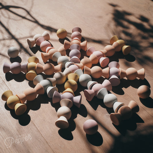 Wooden Chill Pepper Sweets stacking and spinning game for ages 3 and up, made from eco-friendly maple wood and non-toxic, water-based paints. The set includes 27 pastel-colored candy-shaped pieces and 6 gumballs for open-ended play.