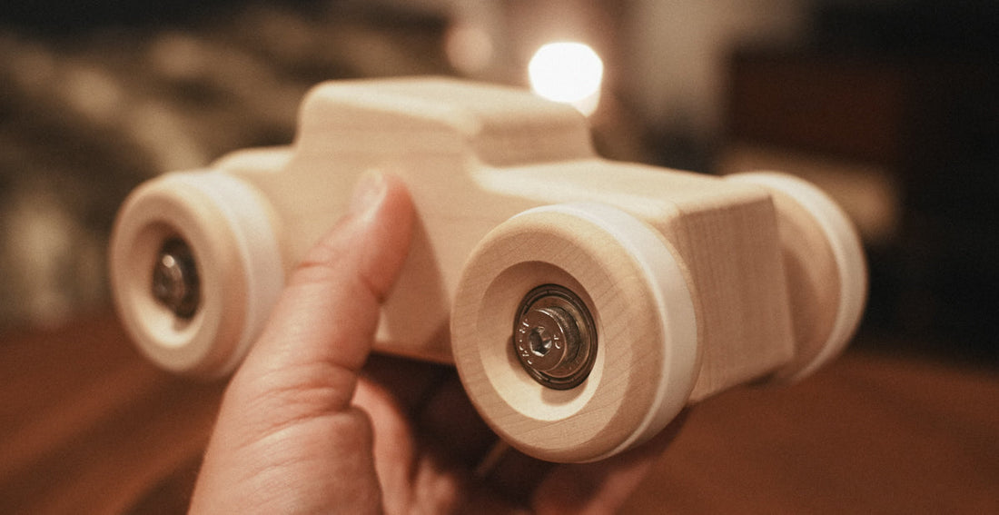 Hand held picture of a solid wooden prototype of the Chunkies Hot Rod toy car to show the quality of the sustainable wood and finish
