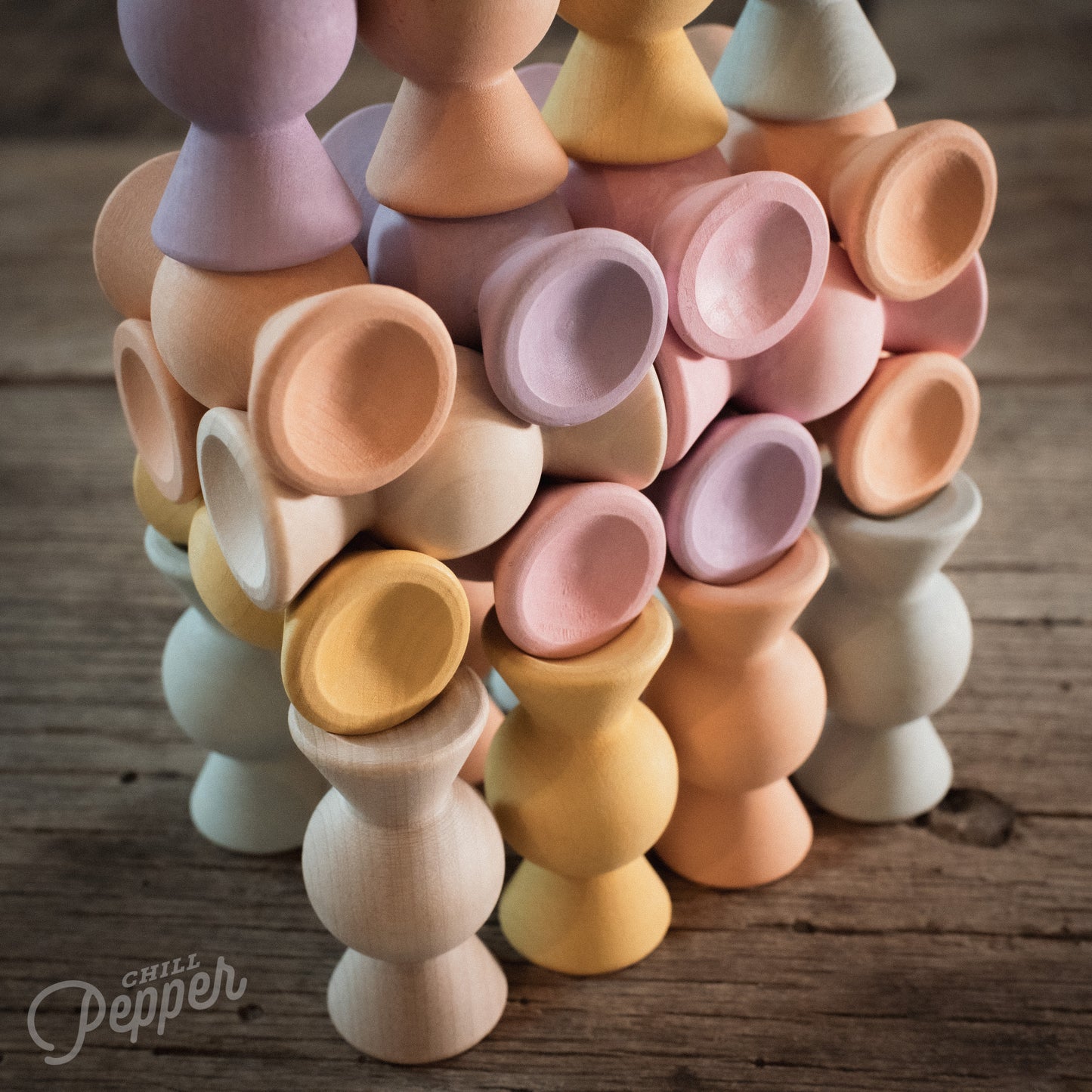Wooden Chill Pepper Sweets stacking and spinning game for ages 3 and up, made from eco-friendly maple wood and non-toxic, water-based paints. The set includes 27 pastel-colored candy-shaped pieces and 6 gumballs for open-ended play.
