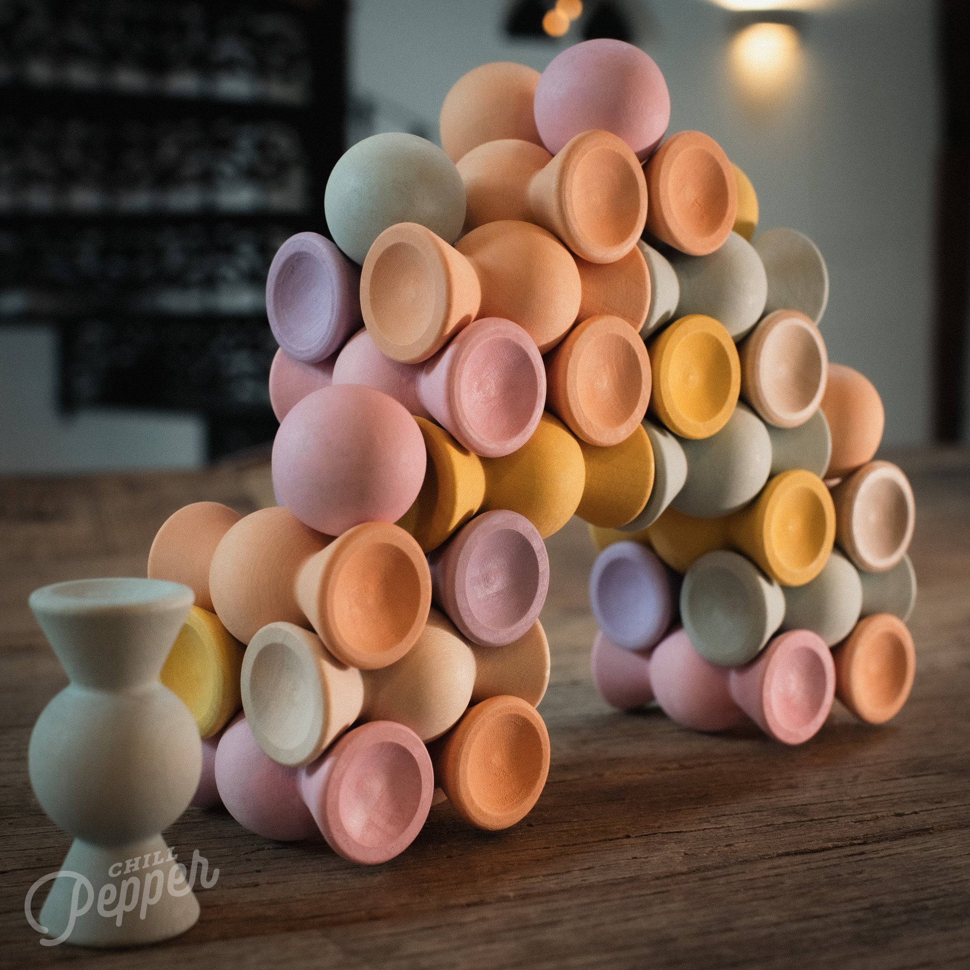 Wooden Chill Pepper Sweets stacking and spinning game for ages 3 and up, made from eco-friendly maple wood and non-toxic, water-based paints. The set includes 27 pastel-colored candy-shaped pieces and 6 gumballs for open-ended play.