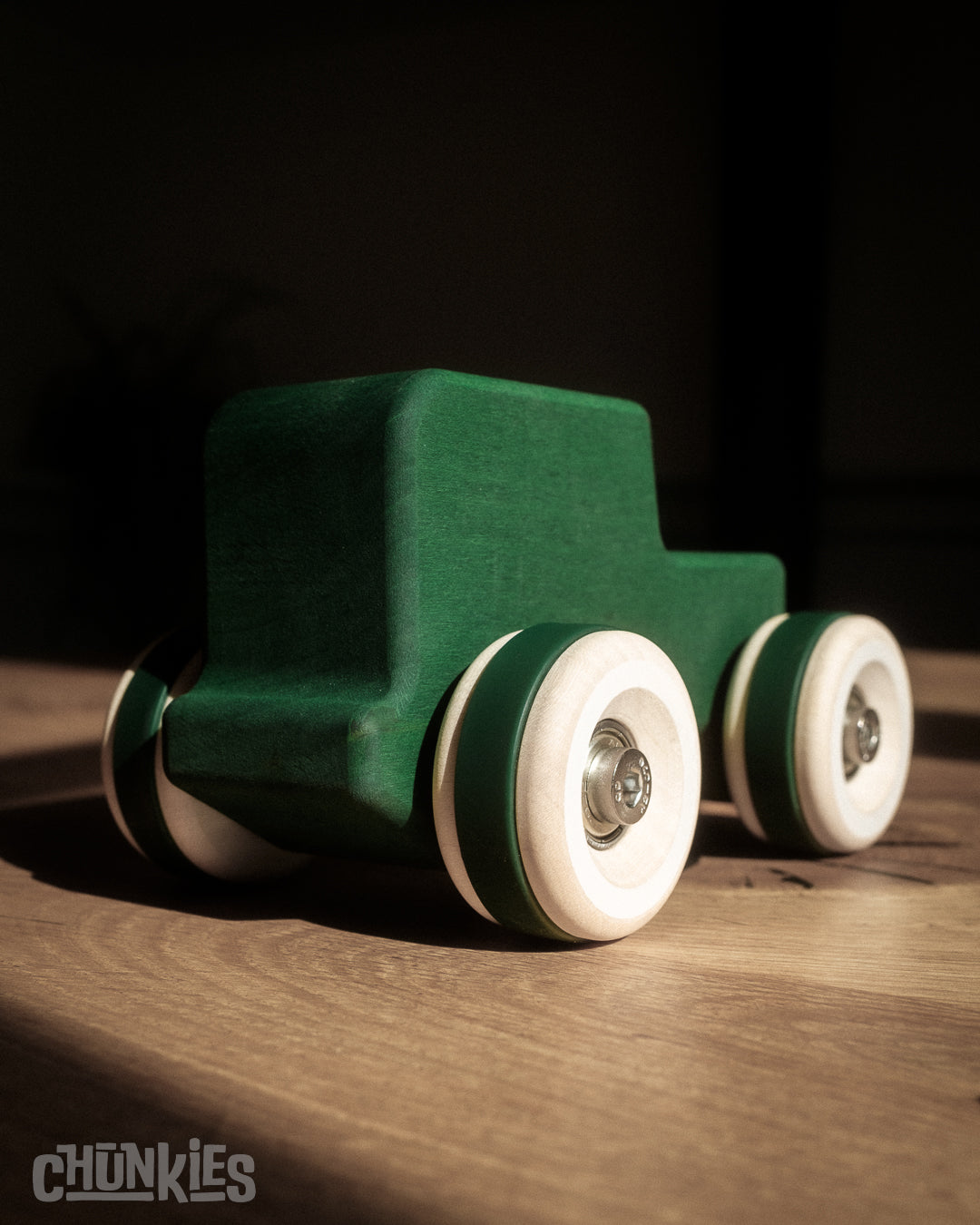 Green wooden toy car in the shape of a vintage 4WD with wooden wheels, skate bearings and stainless steel hardware. Built to last generations.