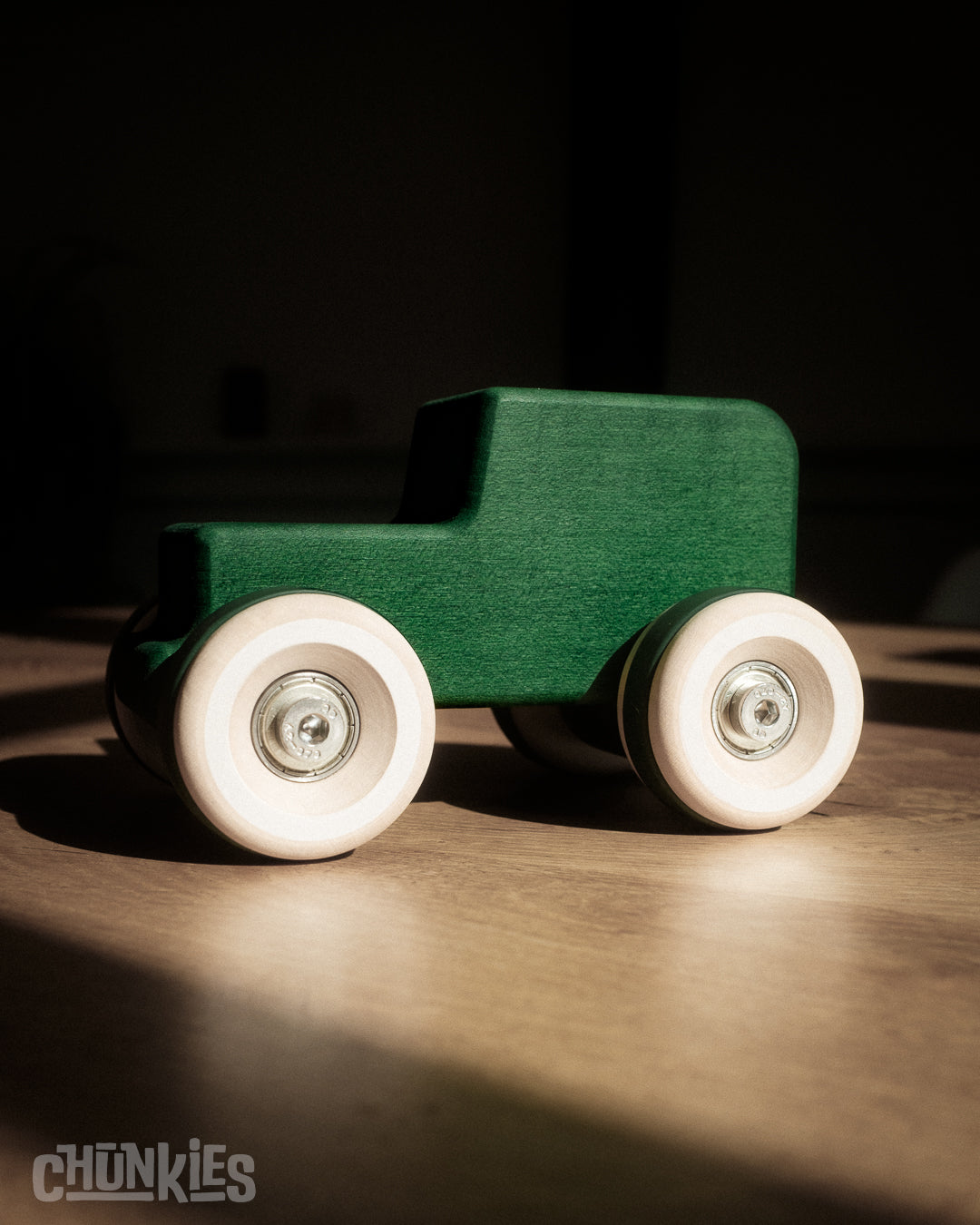 Green wooden toy car in the shape of a vintage 4WD with wooden wheels, skate bearings and stainless steel hardware. Built to last generations.