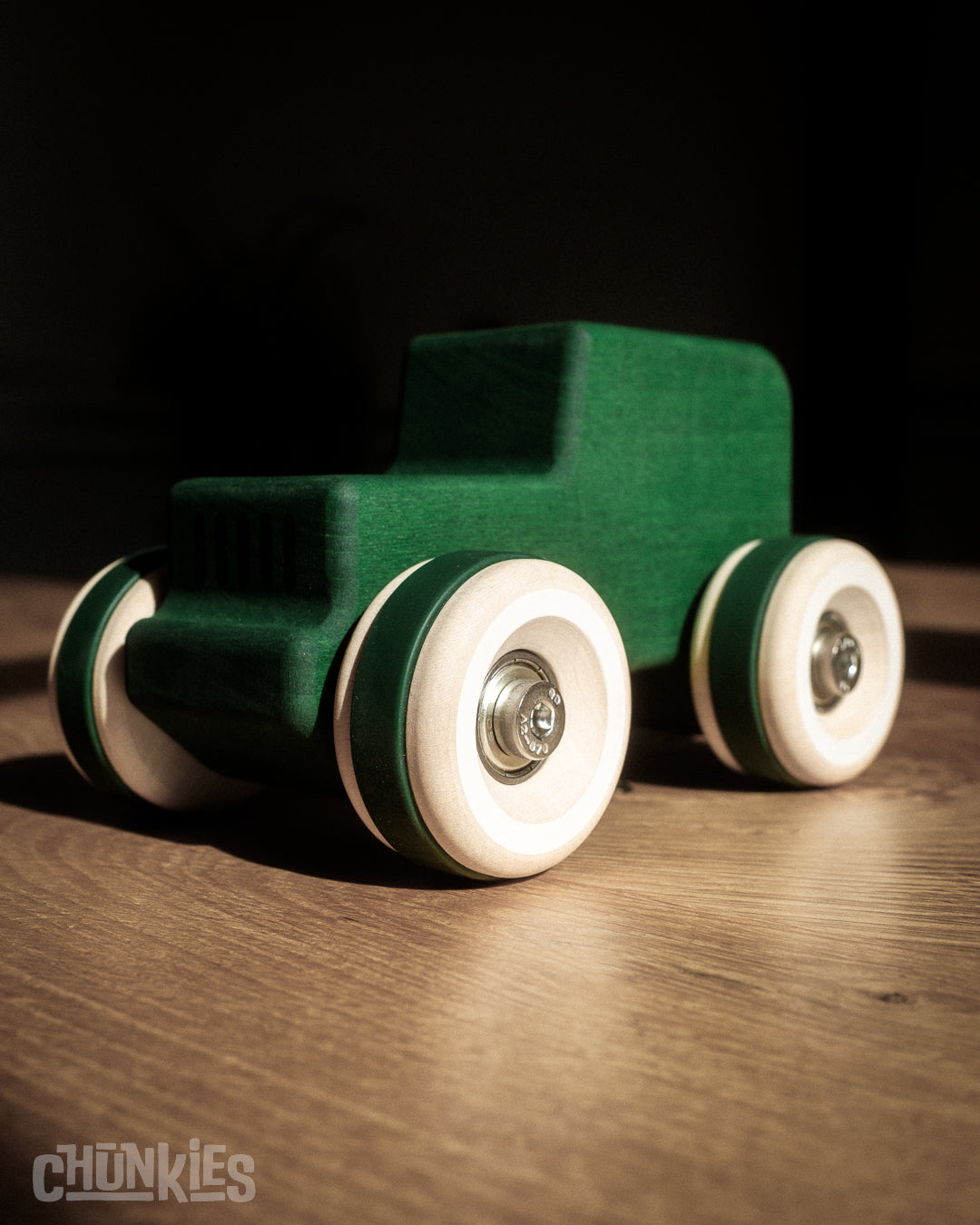 Green wooden toy car in the shape of a vintage 4WD with wooden wheels, skate bearings and stainless steel hardware. Built to last generations.
