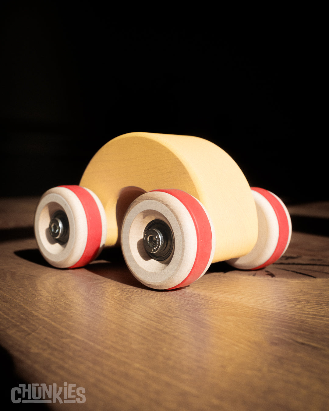 Chunkies: Yellow wooden toy car in the shape of a arch with wooden wheels, skate bearings and stainless steel hardware. Built to last generations. 