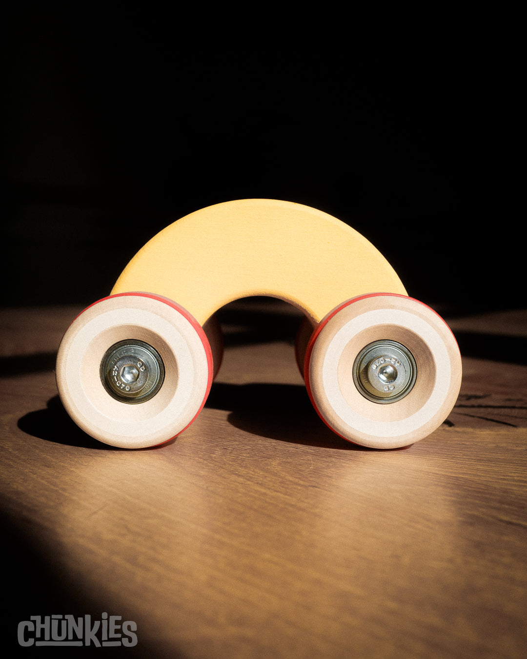 Chunkies: Yellow wooden toy car in the shape of a arch with wooden wheels, skate bearings and stainless steel hardware. Built to last generations. 