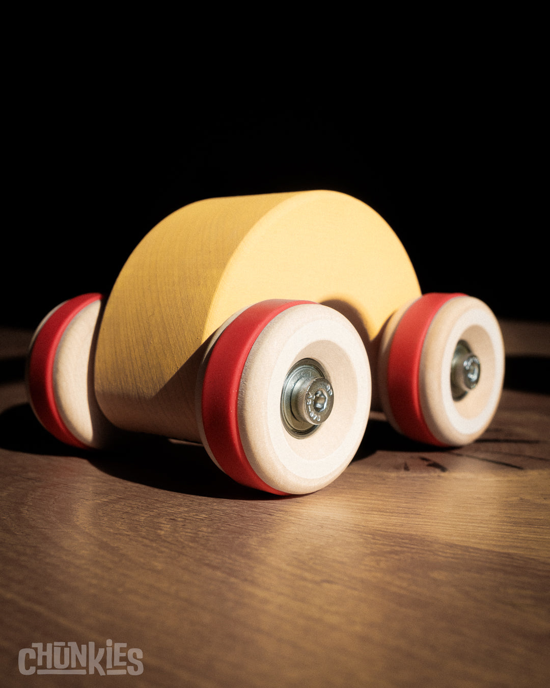 Chunkies: Yellow wooden toy car in the shape of a arch with wooden wheels, skate bearings and stainless steel hardware. Built to last generations. 
