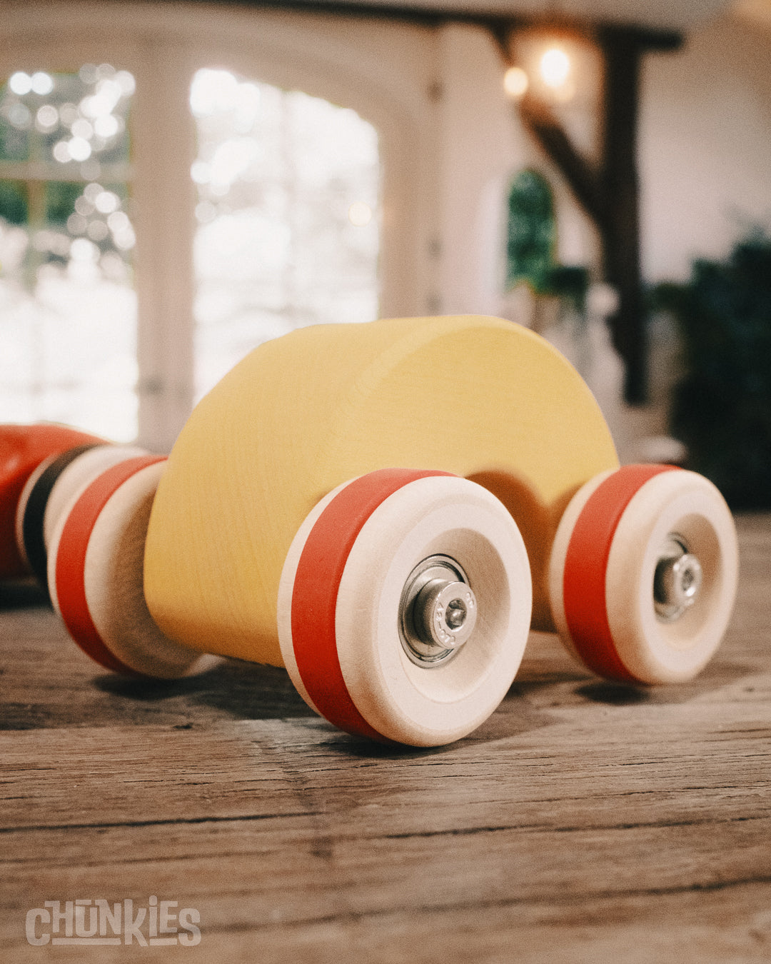 Chunkies: Yellow wooden toy car in the shape of a arch with wooden wheels, skate bearings and stainless steel hardware. Built to last generations. 