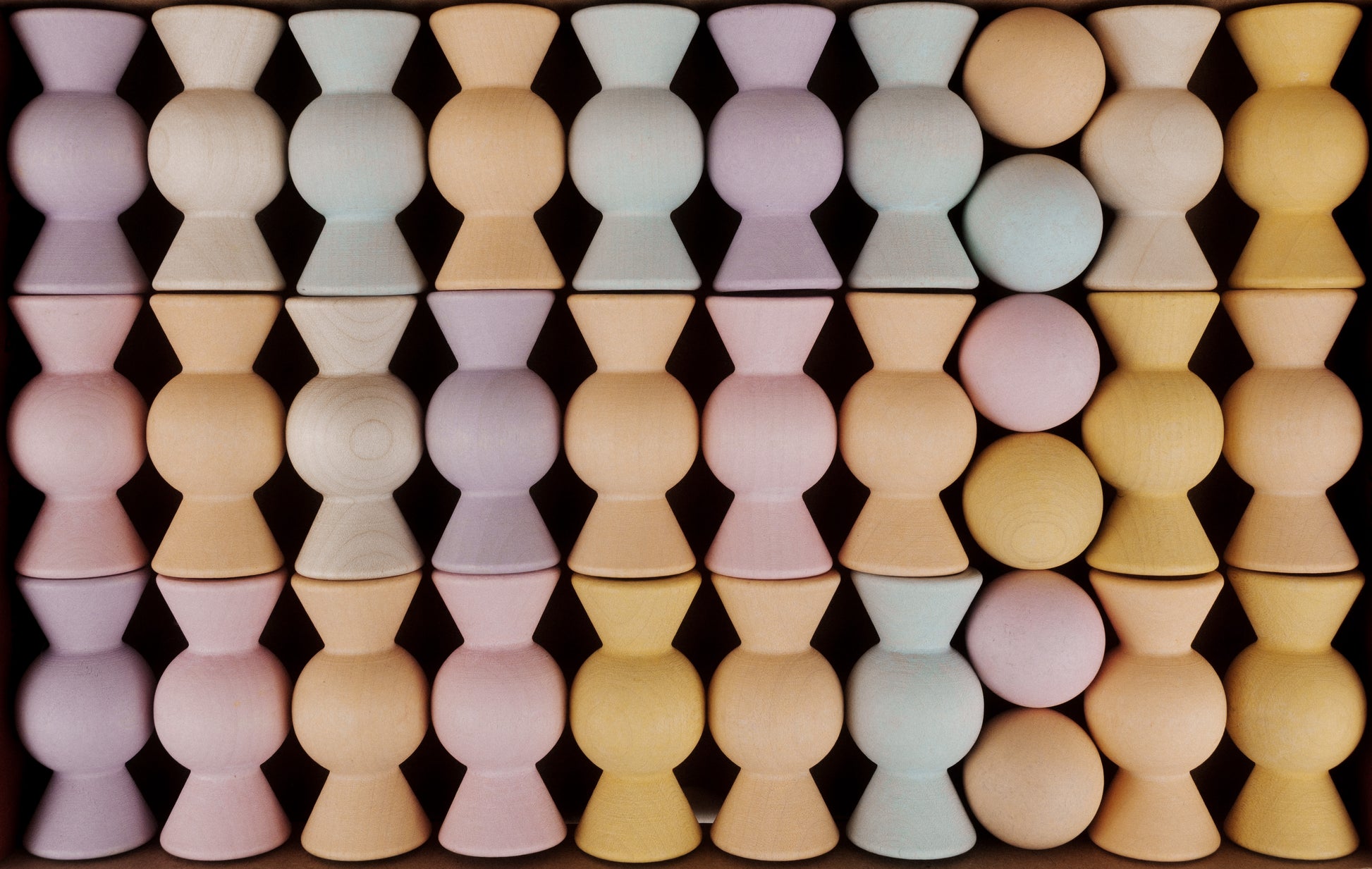 Wooden Chill Pepper Sweets stacking and spinning game for ages 3 and up, made from eco-friendly maple wood and non-toxic, water-based paints. The set includes 27 pastel-colored candy-shaped pieces and 6 gumballs for open-ended play.