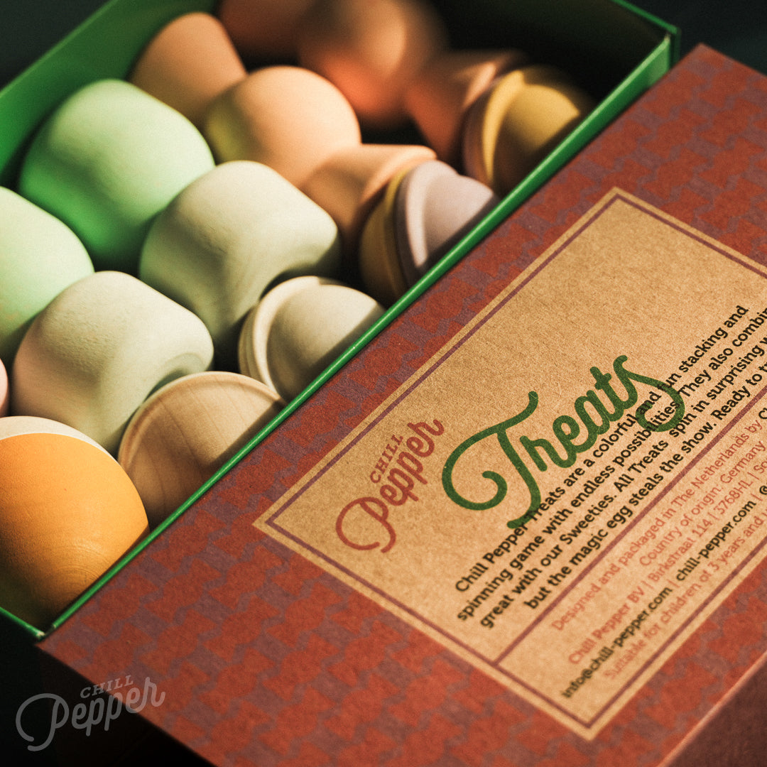 Wooden Chill Pepper Treats stacking and spinning game for ages 3 and up, made from eco-friendly maple wood and non-toxic, water-based paints. The set includes a variety of pastel-colored candy-shaped pieces and a unique Magic Egg for open-ended play.