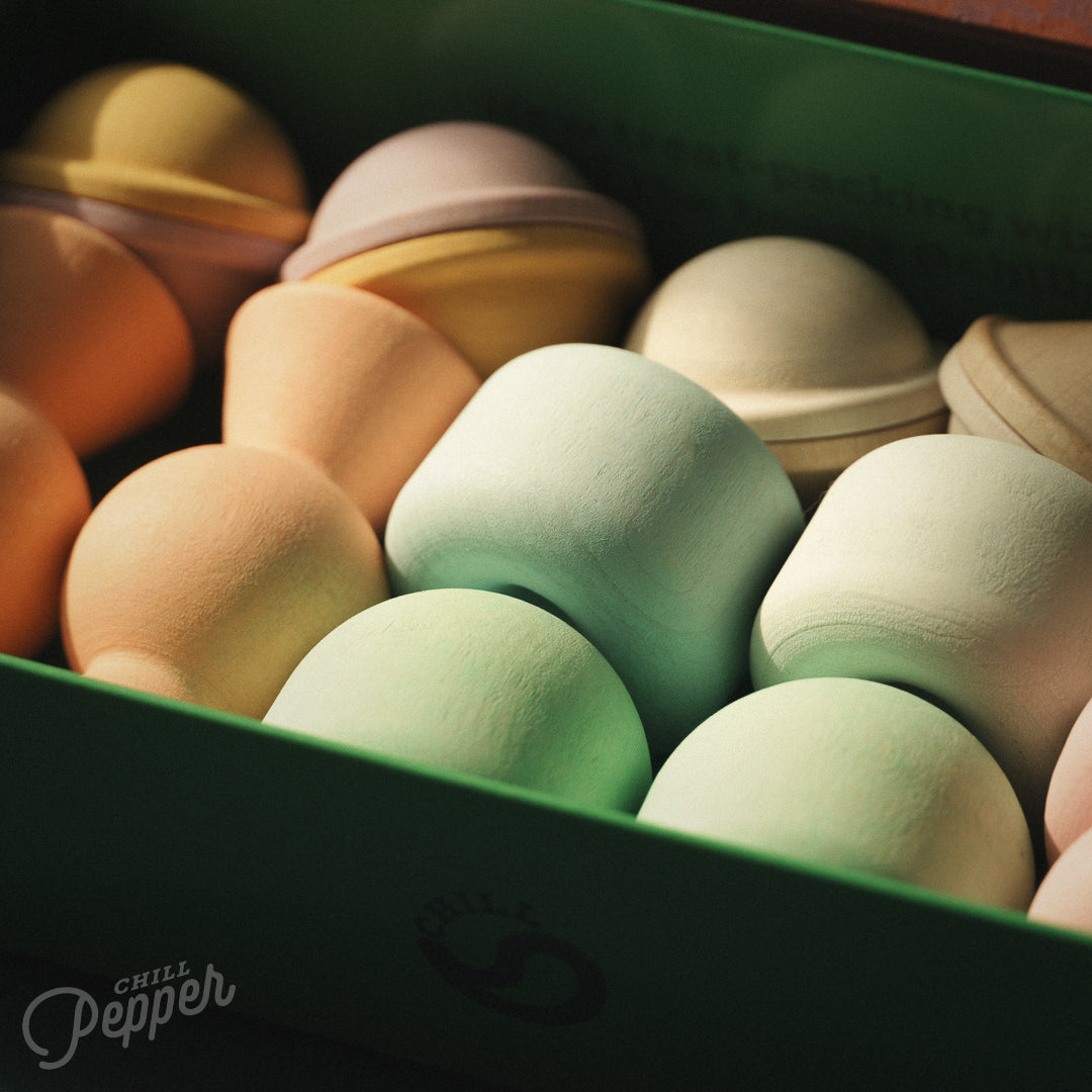Wooden Chill Pepper Treats stacking and spinning game for ages 3 and up, made from eco-friendly maple wood and non-toxic, water-based paints. The set includes a variety of pastel-colored candy-shaped pieces and a unique Magic Egg for open-ended play.