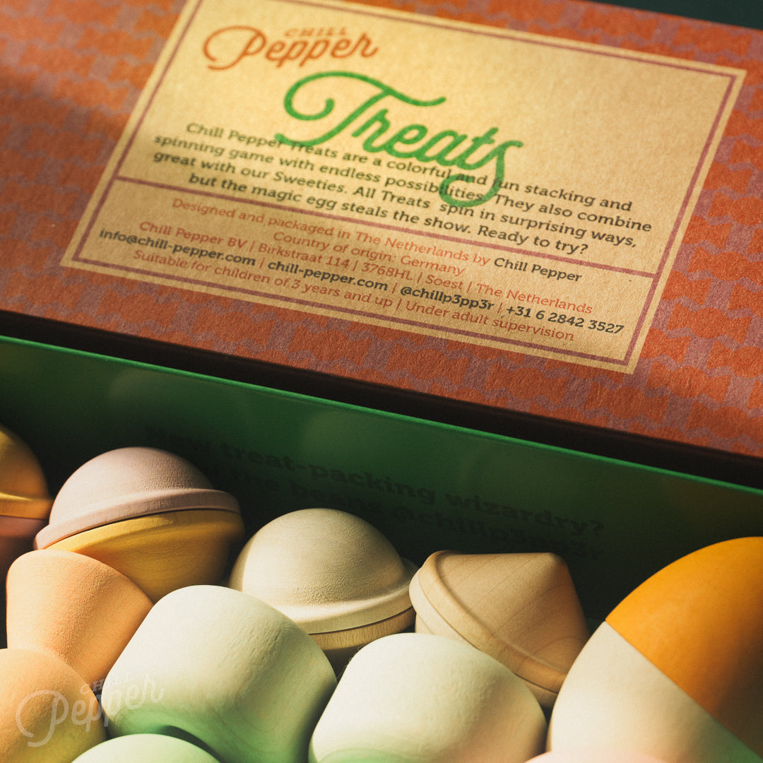 Wooden Chill Pepper Treats stacking and spinning game for ages 3 and up, made from eco-friendly maple wood and non-toxic, water-based paints. The set includes a variety of pastel-colored candy-shaped pieces and a unique Magic Egg for open-ended play.