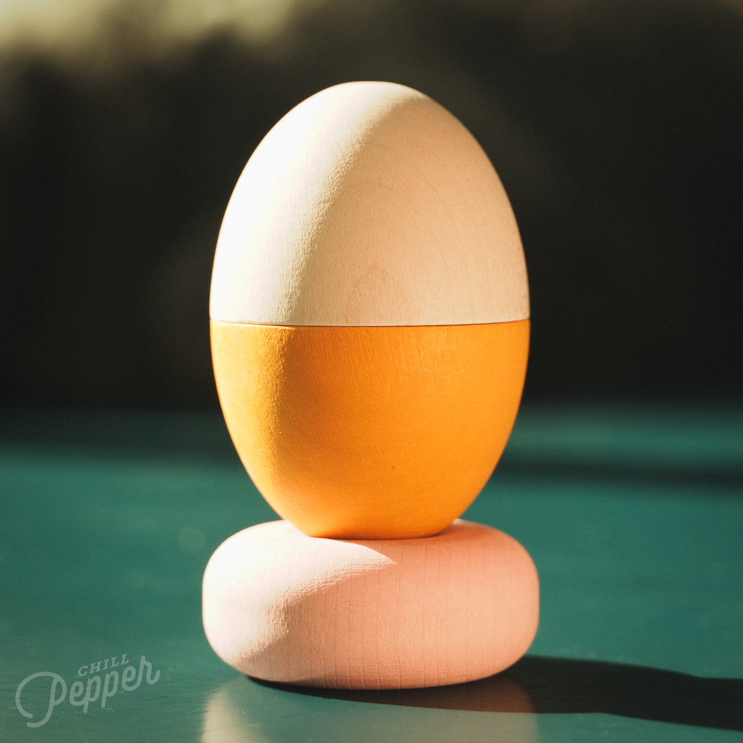 Wooden Chill Pepper Treats stacking and spinning game for ages 3 and up, made from eco-friendly maple wood and non-toxic, water-based paints. The set includes a variety of pastel-colored candy-shaped pieces and a unique Magic Egg for open-ended play.