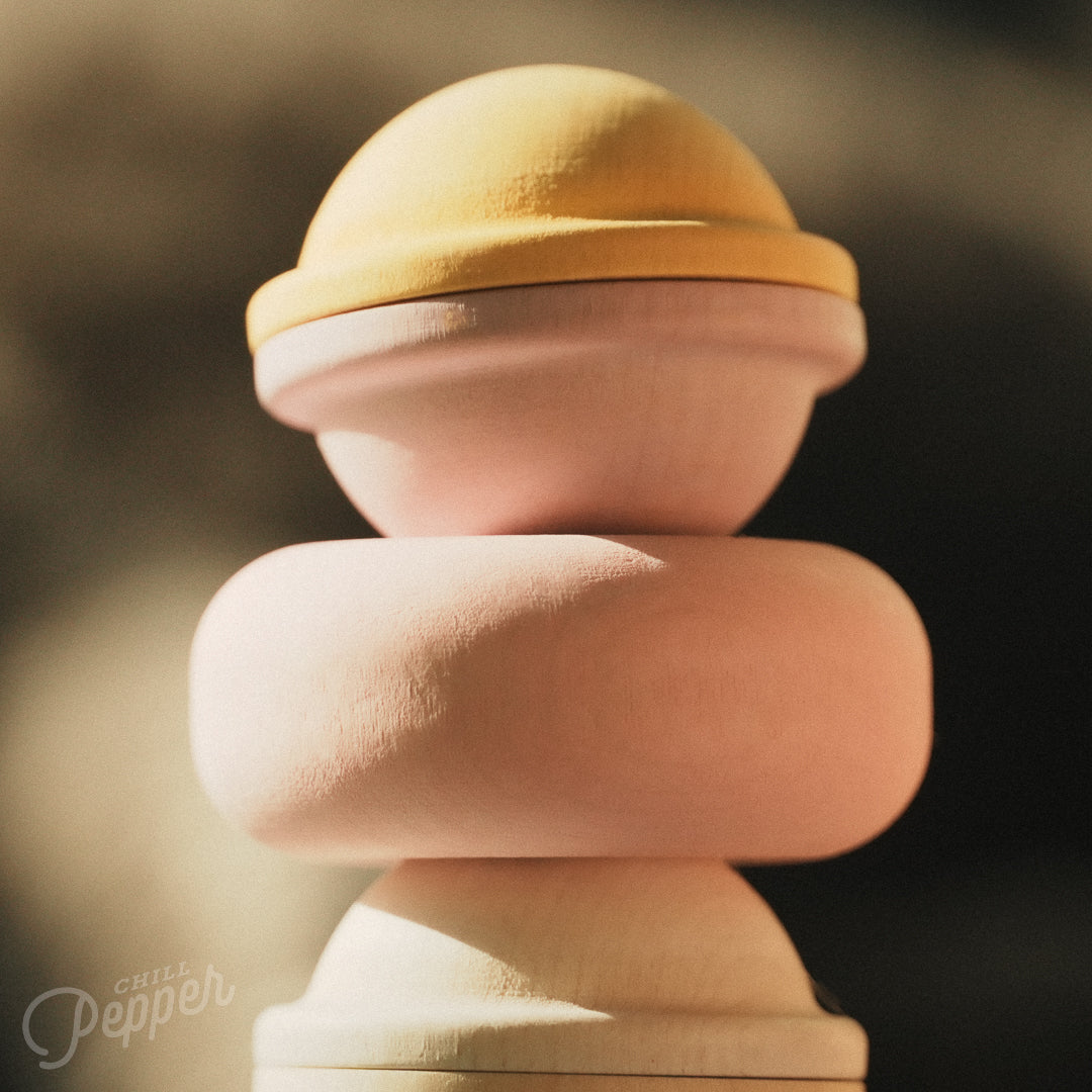 Wooden Chill Pepper Treats stacking and spinning game for ages 3 and up, made from eco-friendly maple wood and non-toxic, water-based paints. The set includes a variety of pastel-colored candy-shaped pieces and a unique Magic Egg for open-ended play.