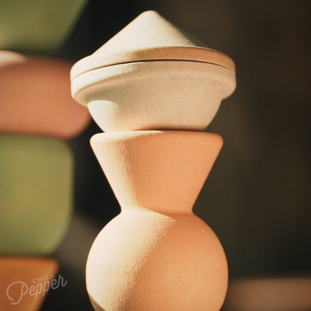 Wooden Chill Pepper Treats stacking and spinning game for ages 3 and up, made from eco-friendly maple wood and non-toxic, water-based paints. The set includes a variety of pastel-colored candy-shaped pieces and a unique Magic Egg for open-ended play.