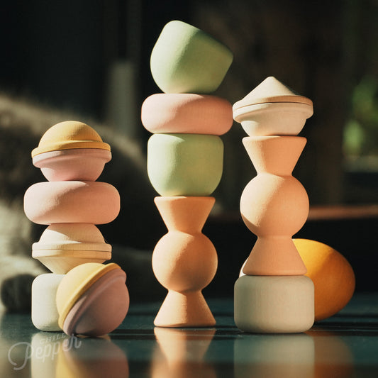 Wooden Chill Pepper Treats stacking and spinning game for ages 3 and up, made from eco-friendly maple wood and non-toxic, water-based paints. The set includes a variety of pastel-colored candy-shaped pieces and a unique Magic Egg for open-ended play.