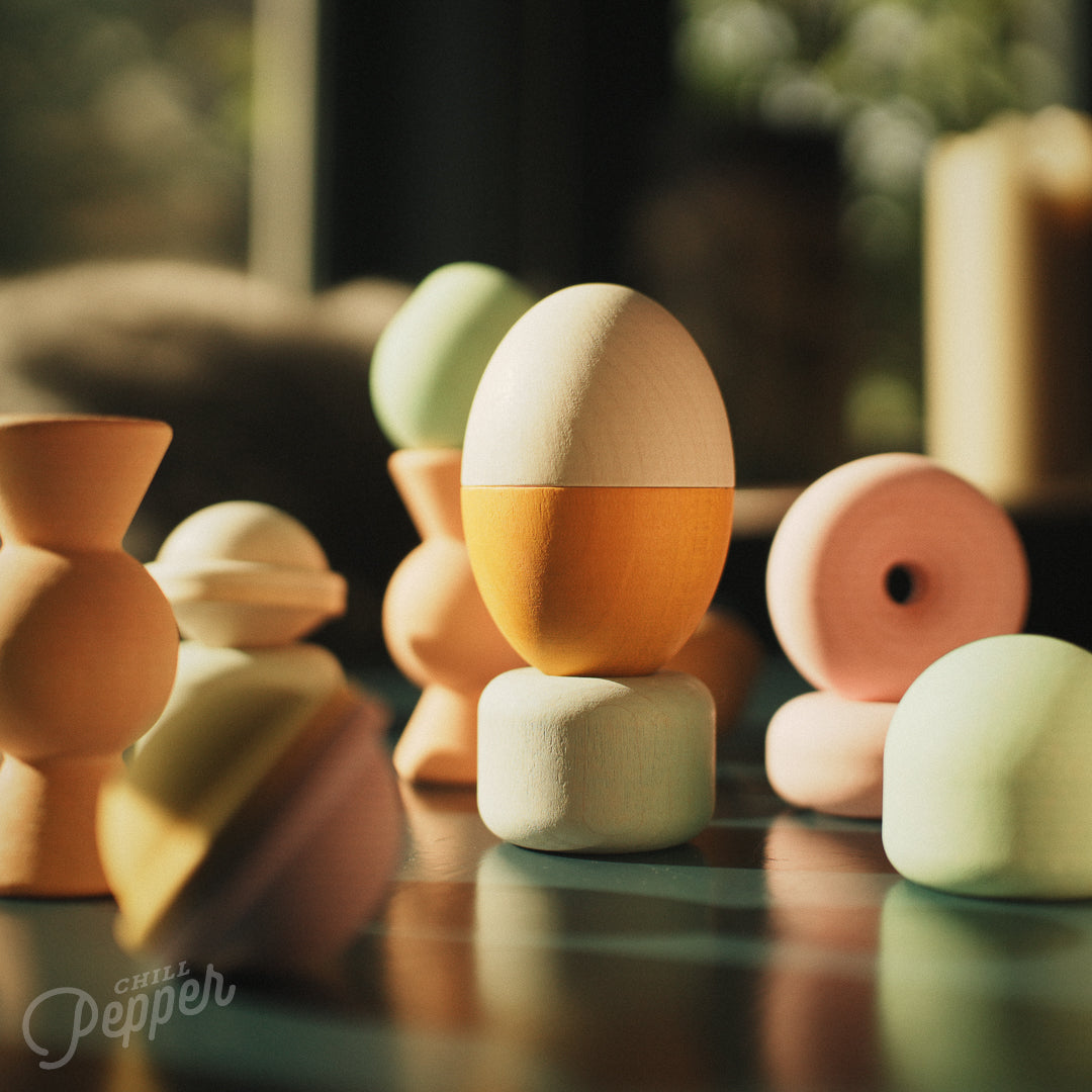 Wooden Chill Pepper Treats stacking and spinning game for ages 3 and up, made from eco-friendly maple wood and non-toxic, water-based paints. The set includes a variety of pastel-colored candy-shaped pieces and a unique Magic Egg for open-ended play.