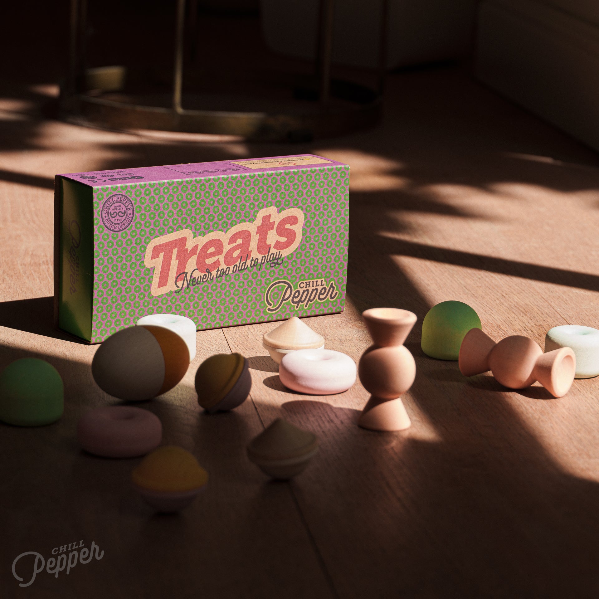 Wooden Chill Pepper Treats stacking and spinning game for ages 3 and up, made from eco-friendly maple wood and non-toxic, water-based paints. The set includes a variety of pastel-colored candy-shaped pieces and a unique Magic Egg for open-ended play.