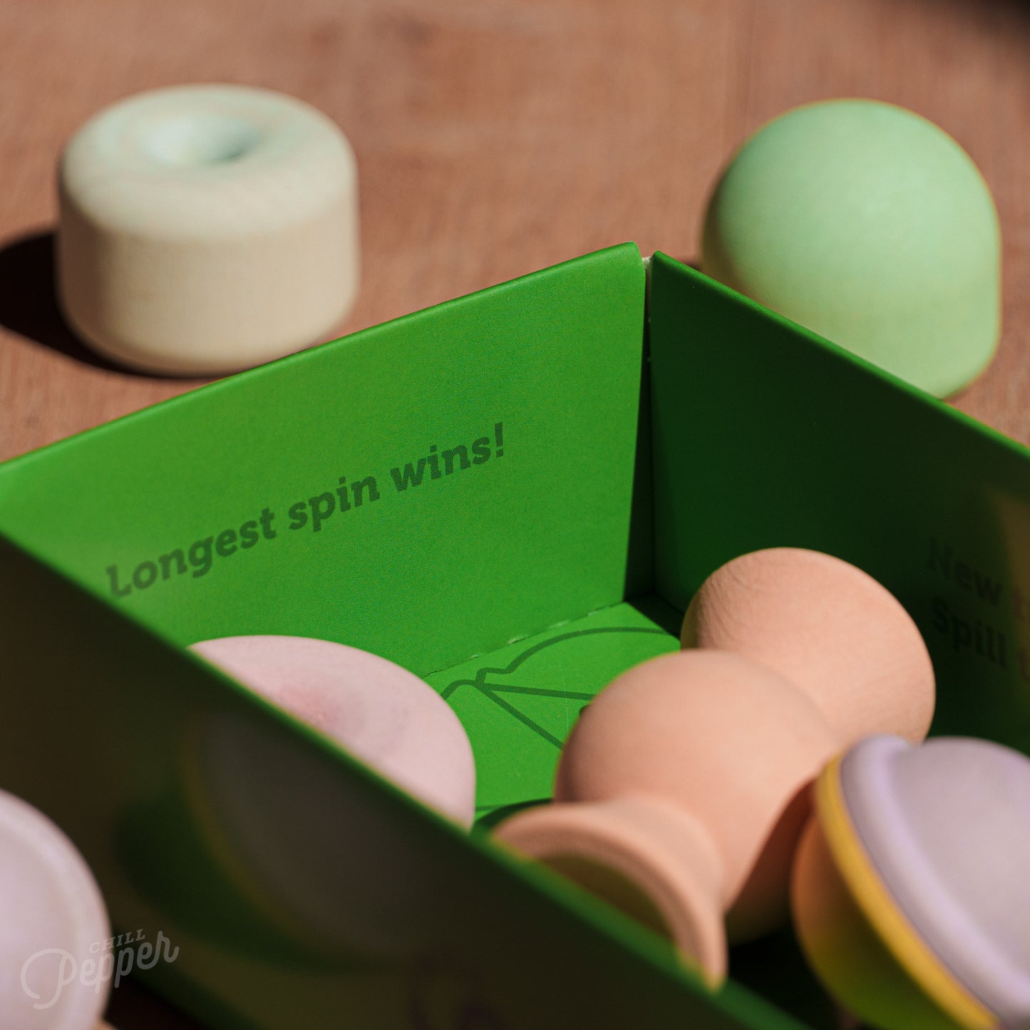 Wooden Chill Pepper Treats stacking and spinning game for ages 3 and up, made from eco-friendly maple wood and non-toxic, water-based paints. The set includes a variety of pastel-colored candy-shaped pieces and a unique Magic Egg for open-ended play.