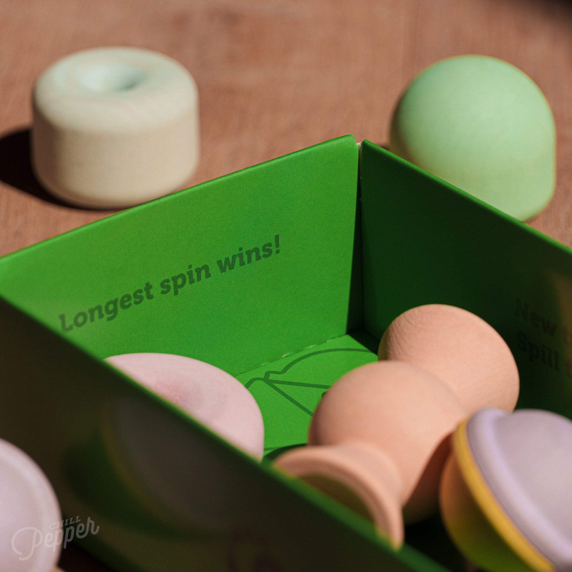 Wooden Chill Pepper Treats stacking and spinning game for ages 3 and up, made from eco-friendly maple wood and non-toxic, water-based paints. The set includes a variety of pastel-colored candy-shaped pieces and a unique Magic Egg for open-ended play.
