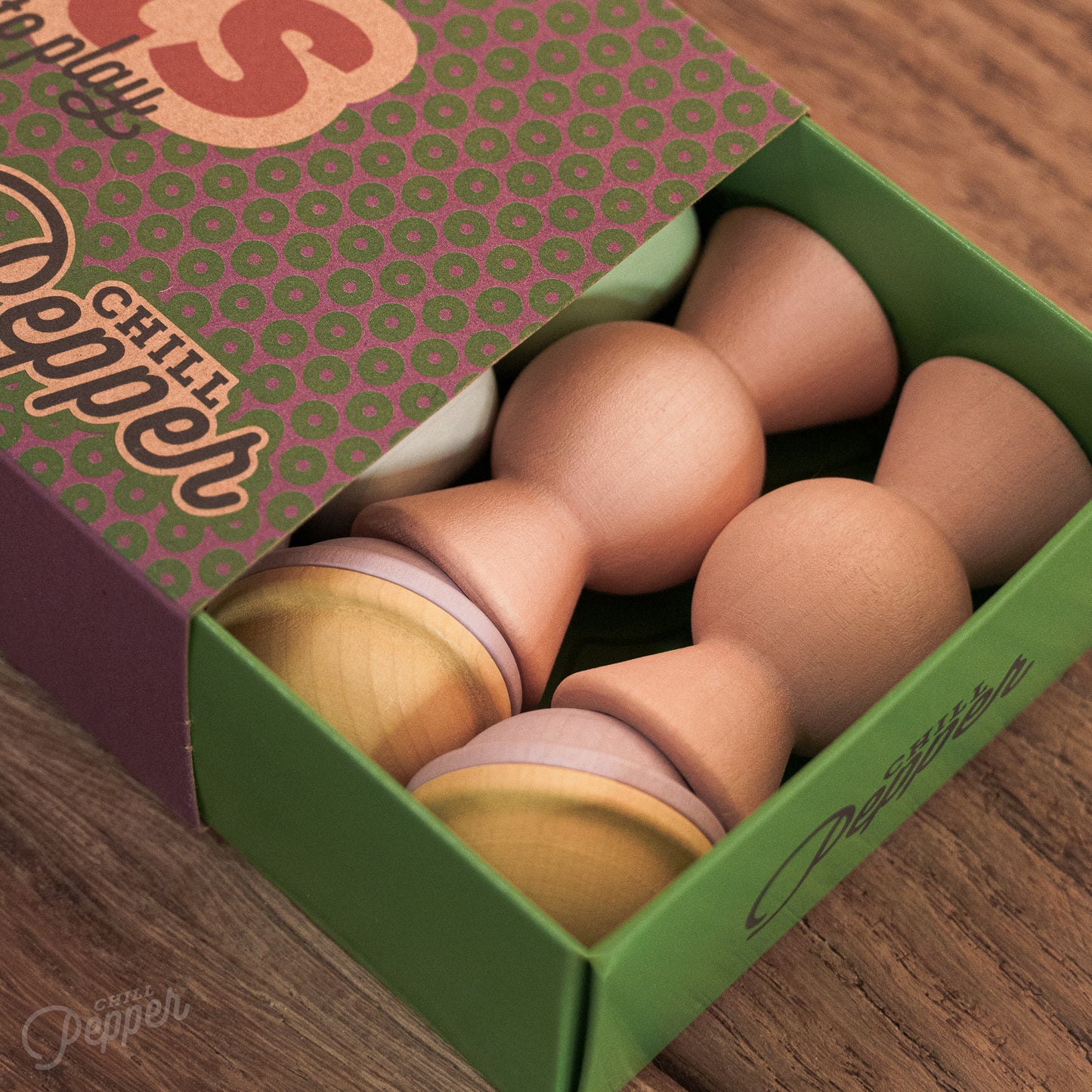 Wooden Chill Pepper Treats stacking and spinning game for ages 3 and up, made from eco-friendly maple wood and non-toxic, water-based paints. The set includes a variety of pastel-colored candy-shaped pieces and a unique Magic Egg for open-ended play.