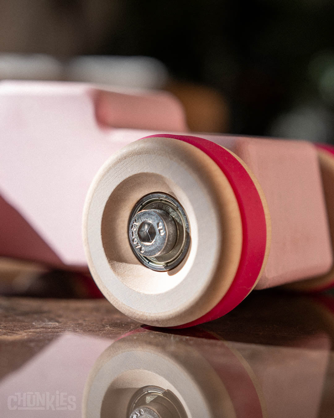 Close-up shot of the big wooden wheels, stainless steel hardware and real smooth skate bearings of the Chunkies hot rod wooden toy car made by Chill Pepper in The Netherlands, Europe