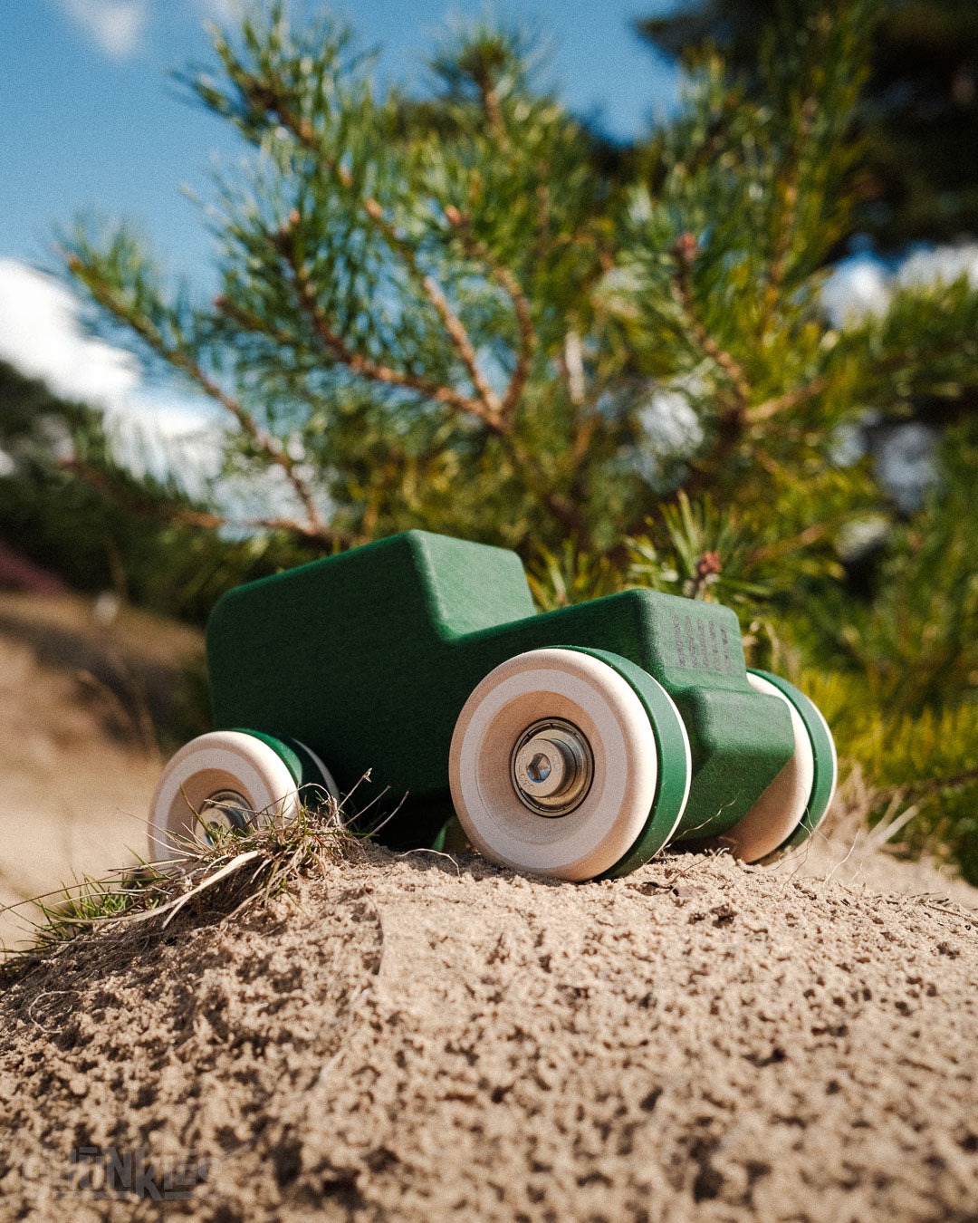 Sand dunes and a forest in he background explored by the Chill Pepper Chunkies No05 Wooden Toy Car All-Terrain