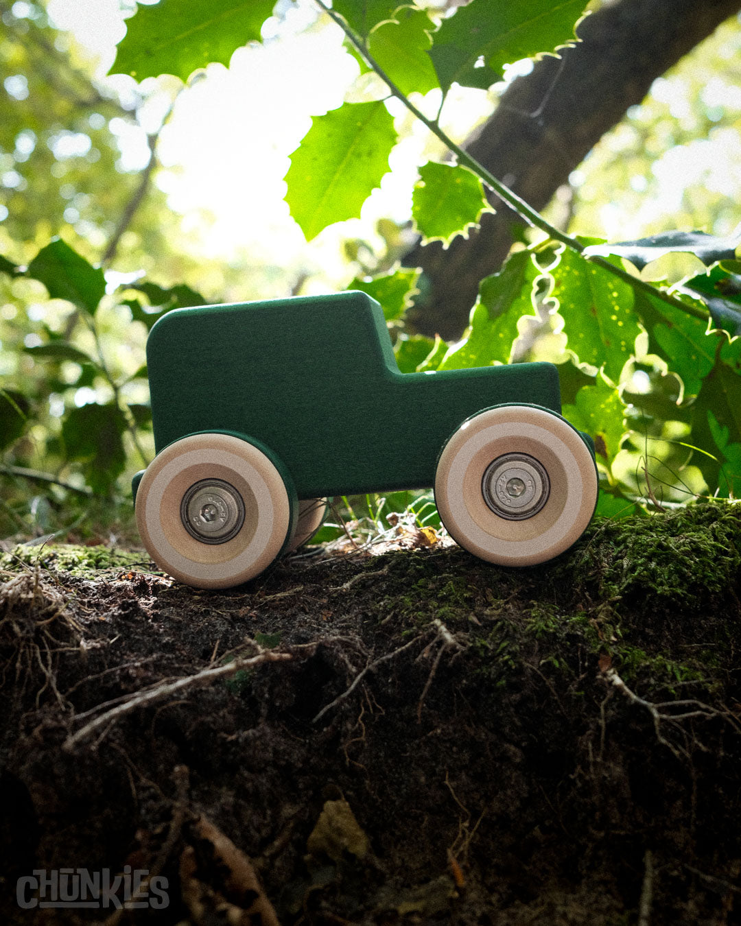 Another forest shot of the Chill Pepper Chunkies No05 Wooden Toy Car The Explorer All-Terrain. Backlit by natural light. Silhouet 