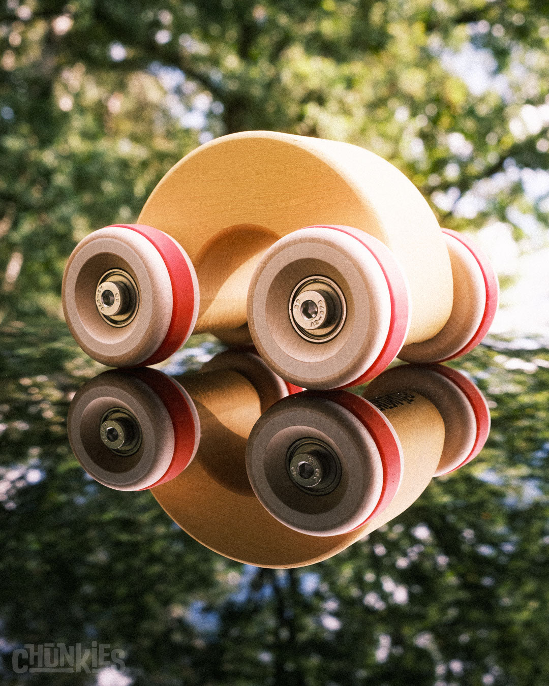 A Chill Pepper Chunkies No06 Wooden Toy Car The Rainbow on top of a reflective surface so you can see underneath too. The Chunkies logo is printed on the bottom to ensure you have the one and only real CHunkies with its world first skate bearings in it's wooden wheels