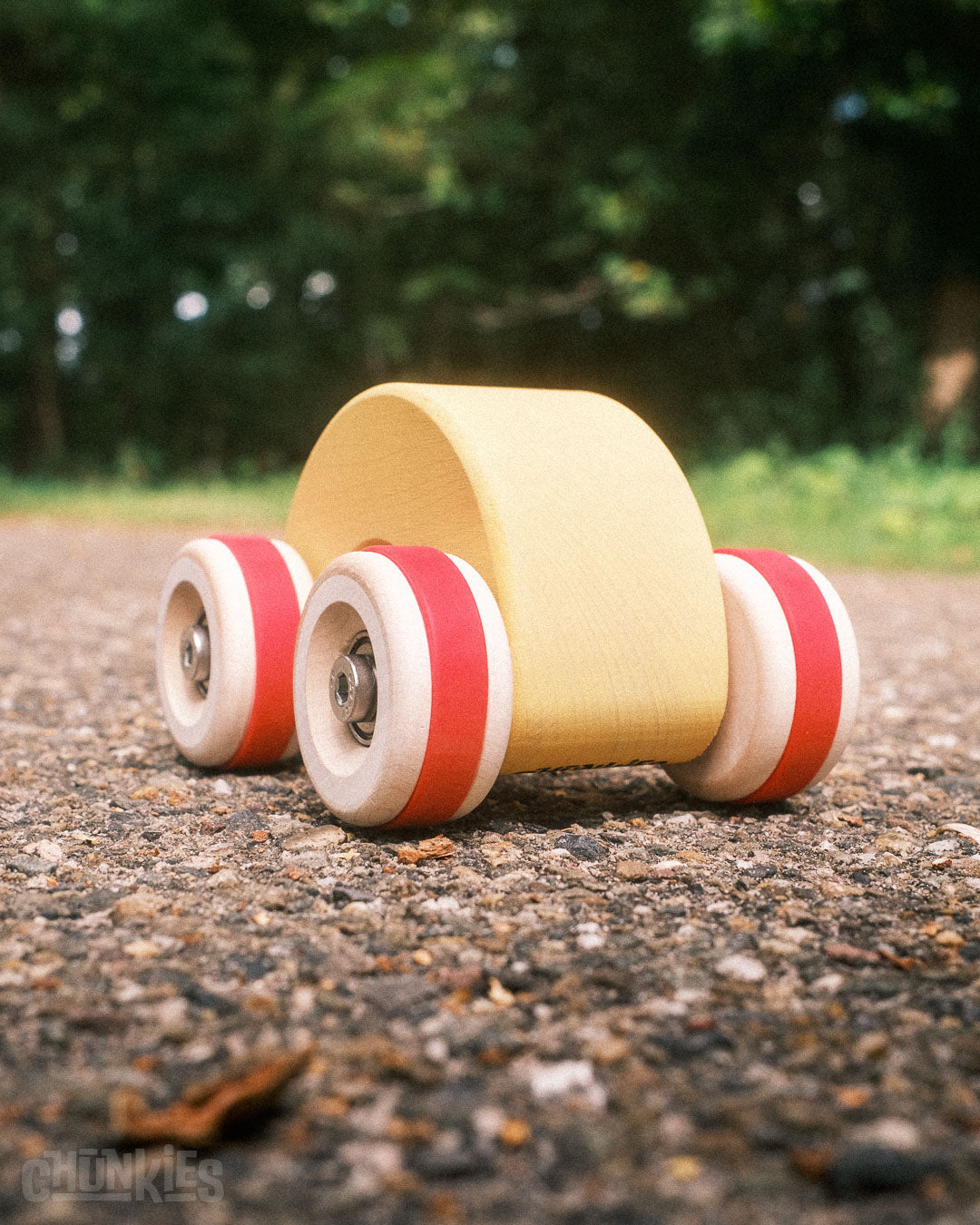 Chill Pepper Chunkies No06 Wooden Toy Car The Rainbow - outdoors with trees in the background on a gravel road: ready for adventure