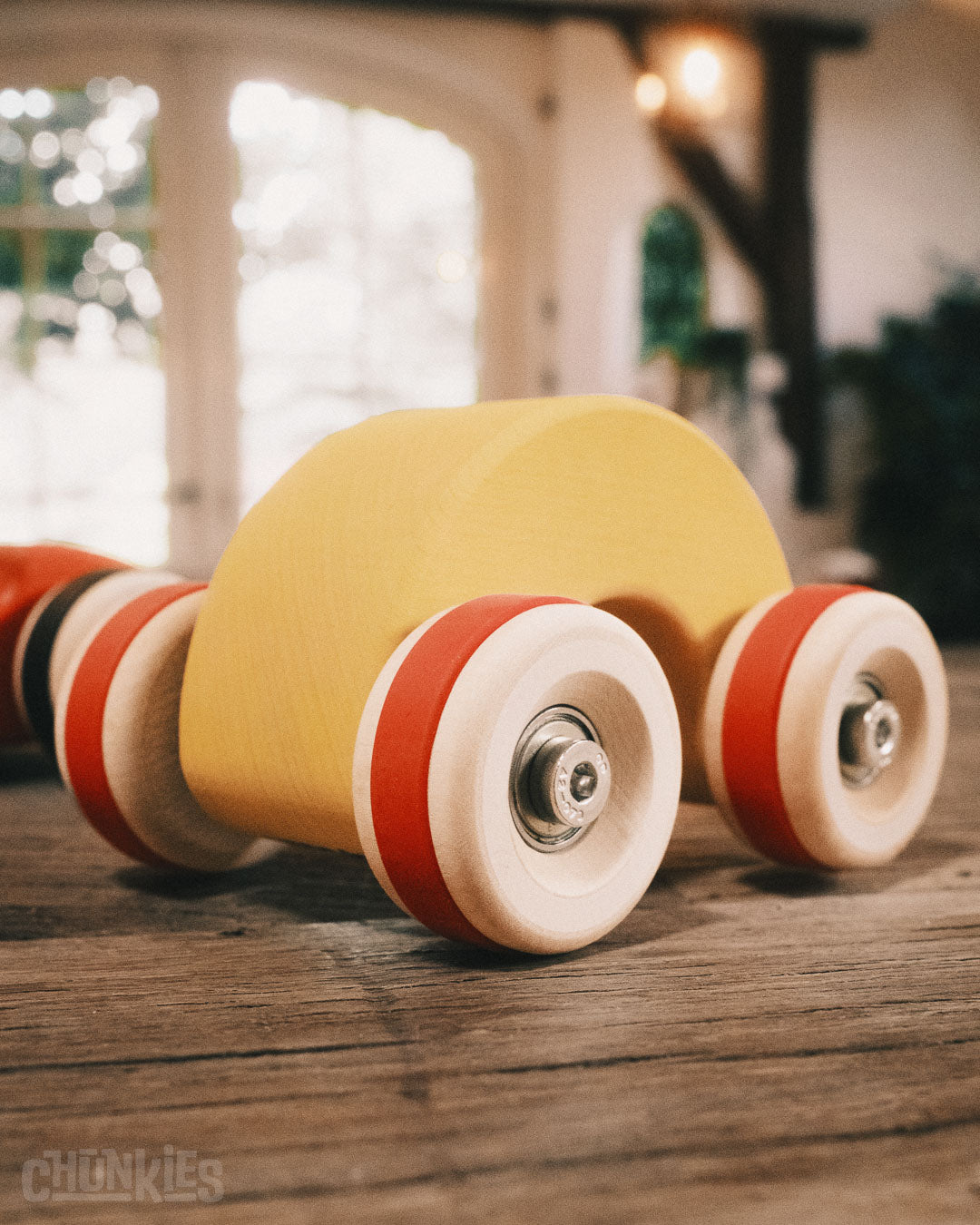 Chill Pepper Chunkies No06 Wooden Toy Car The Rainbow indoors in an old Dutch farmhouse with bright natural light pouring through the windows in the background