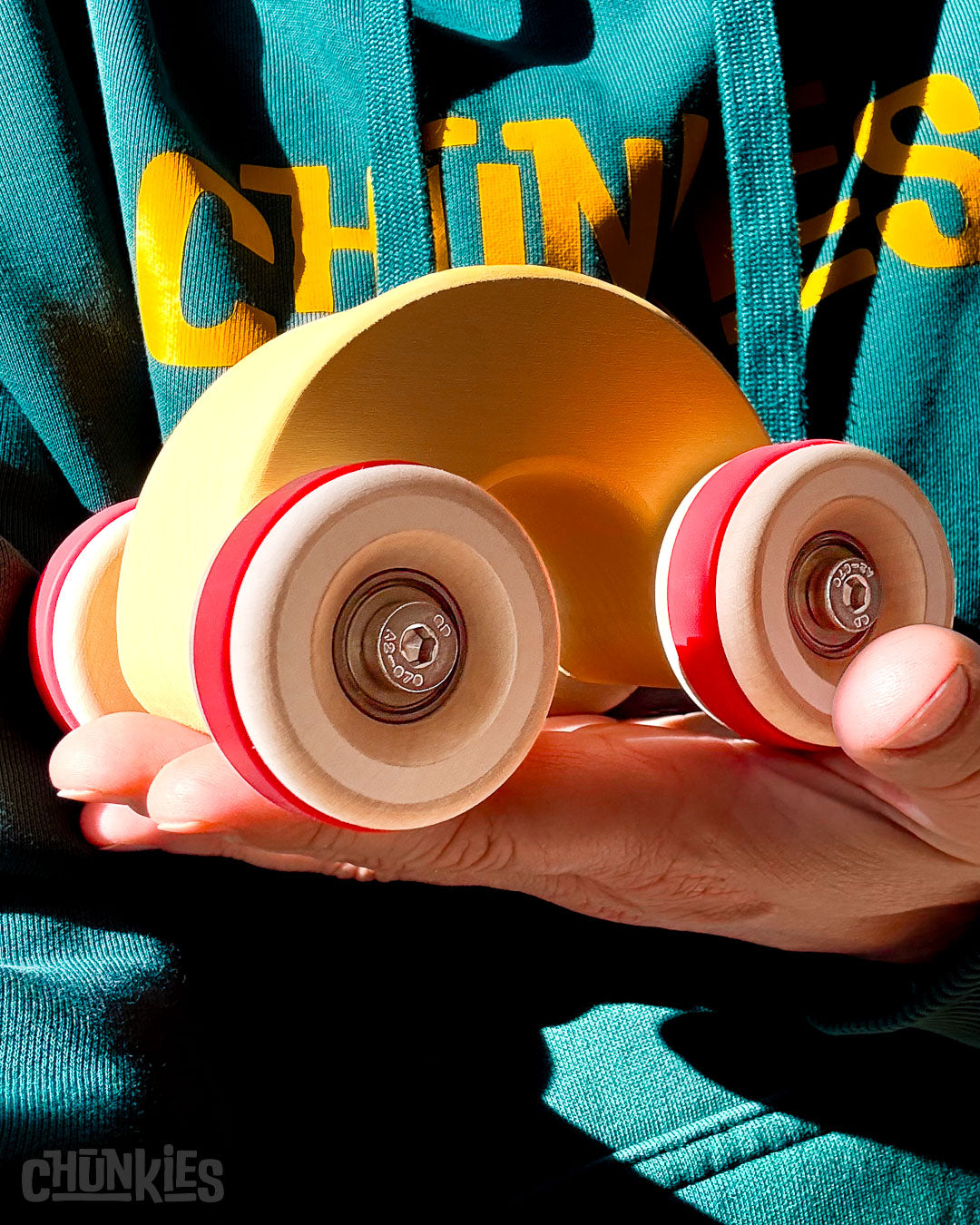 Cose-up of the handheld Chill Pepper Chunkies No06 Wooden Toy Car The Rainbow in bright sunlight.