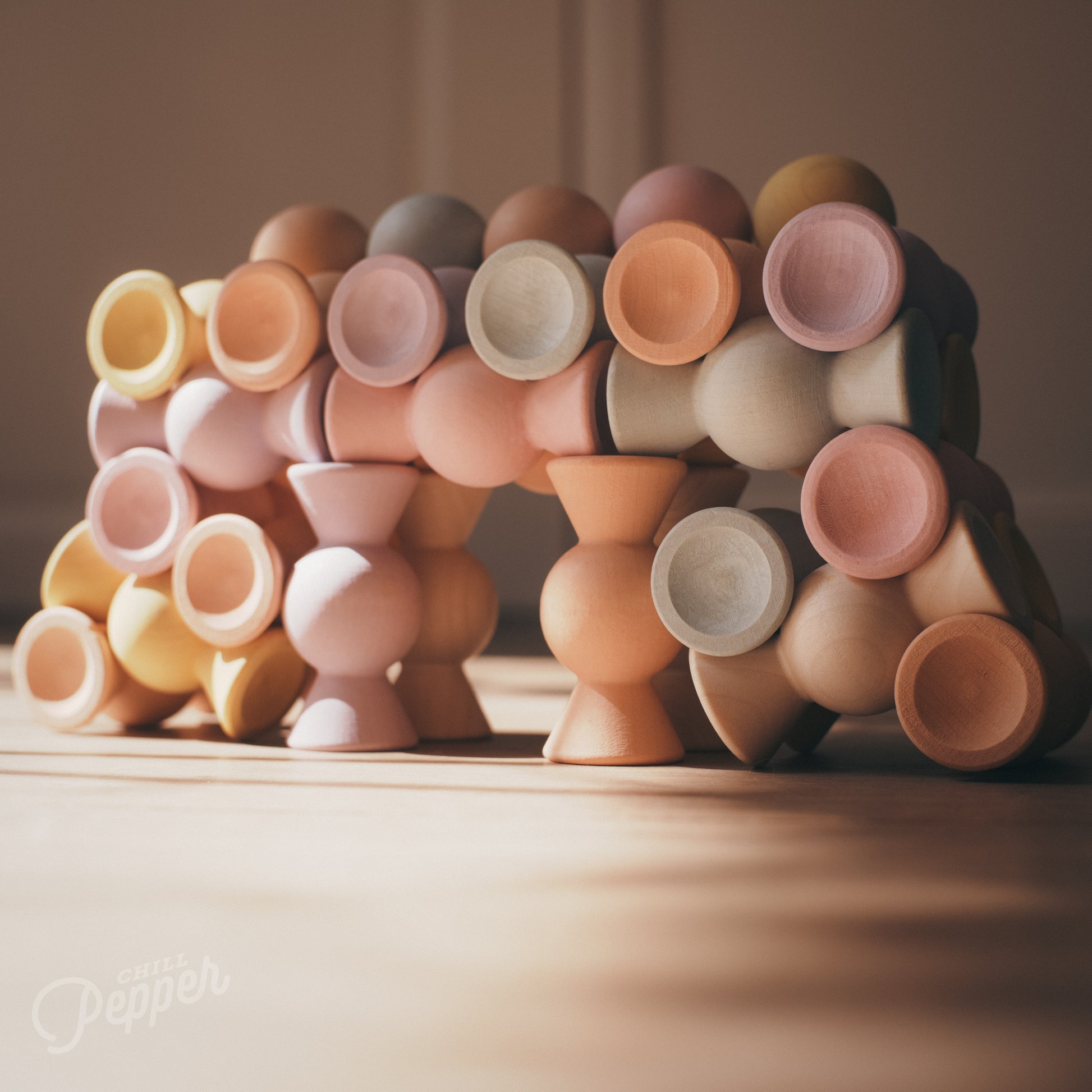 Wooden Chill Pepper Sweets stacking and spinning game for ages 3 and up, made from eco-friendly maple wood and non-toxic, water-based paints. The set includes 27 pastel-colored candy-shaped pieces and 6 gumballs for open-ended play.