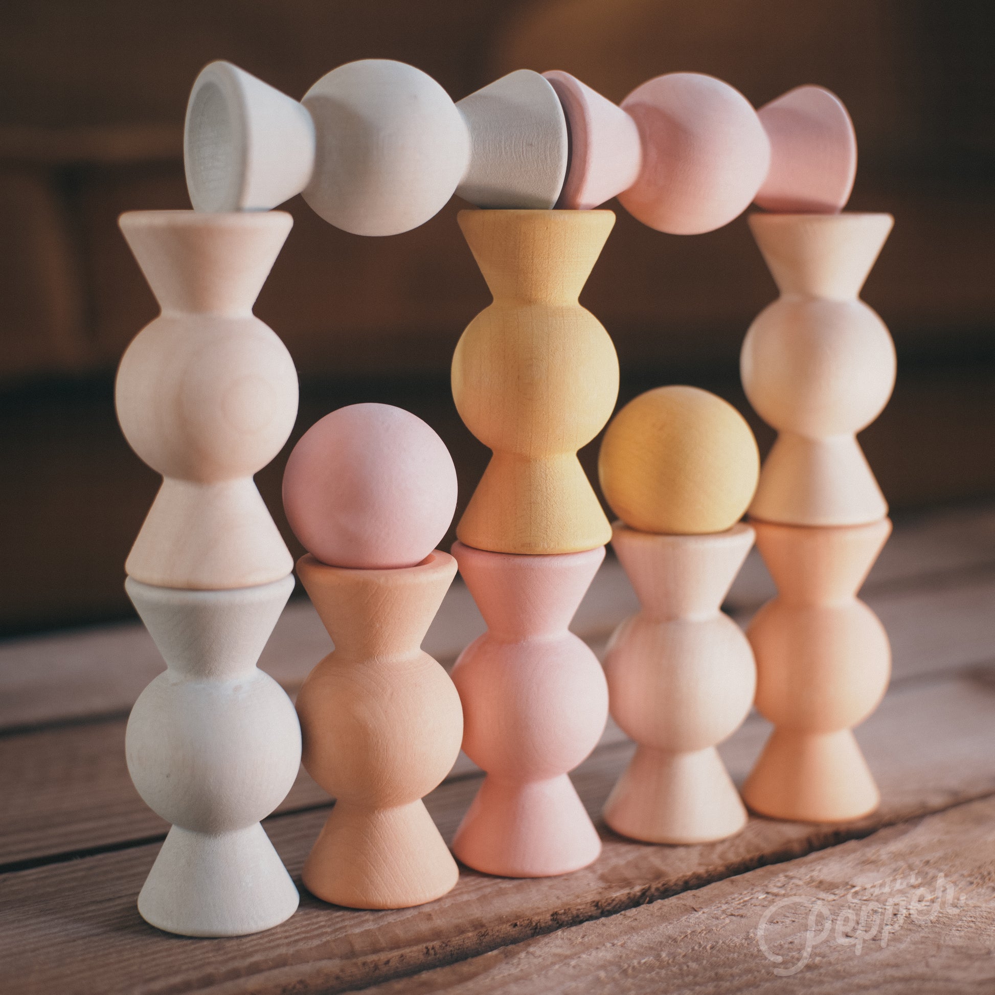 Wooden Chill Pepper Sweets stacking and spinning game for ages 3 and up, made from eco-friendly maple wood and non-toxic, water-based paints. The set includes 27 pastel-colored candy-shaped pieces and 6 gumballs for open-ended play.