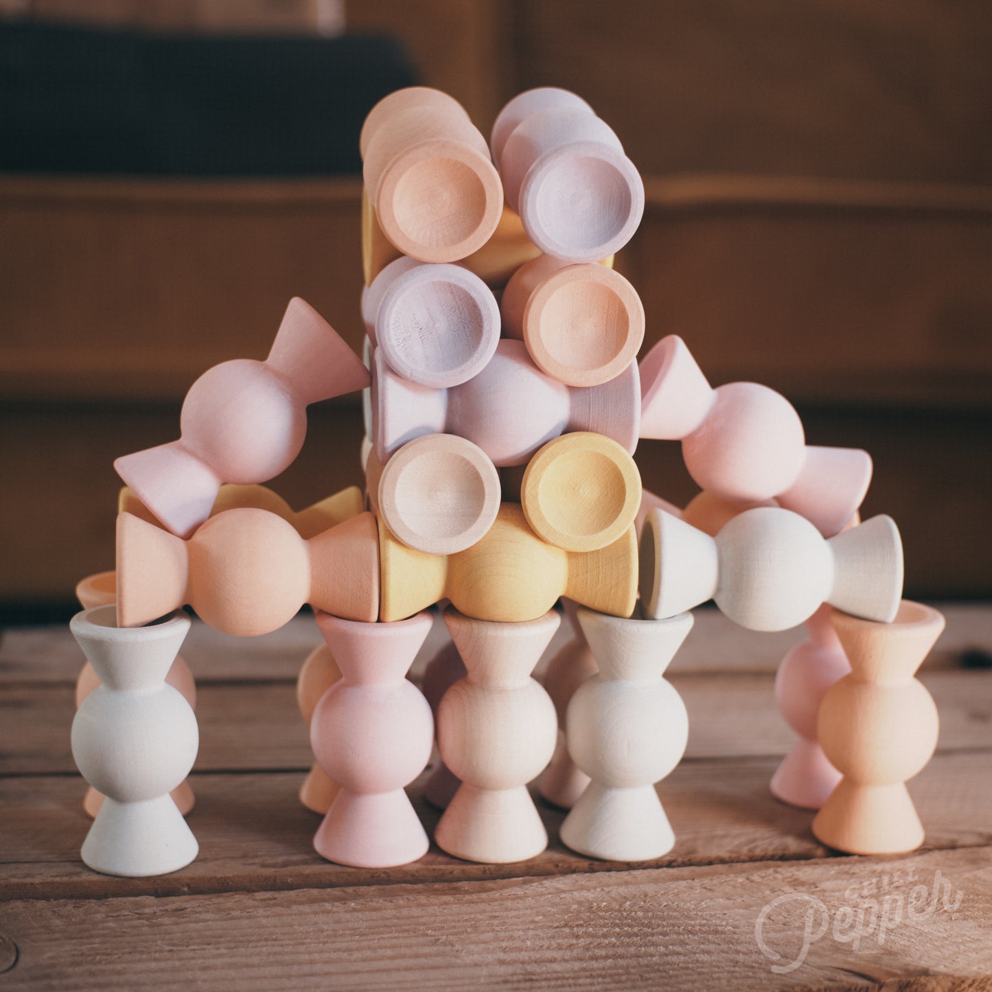 Wooden Chill Pepper Sweets stacking and spinning game for ages 3 and up, made from eco-friendly maple wood and non-toxic, water-based paints. The set includes 27 pastel-colored candy-shaped pieces and 6 gumballs for open-ended play.