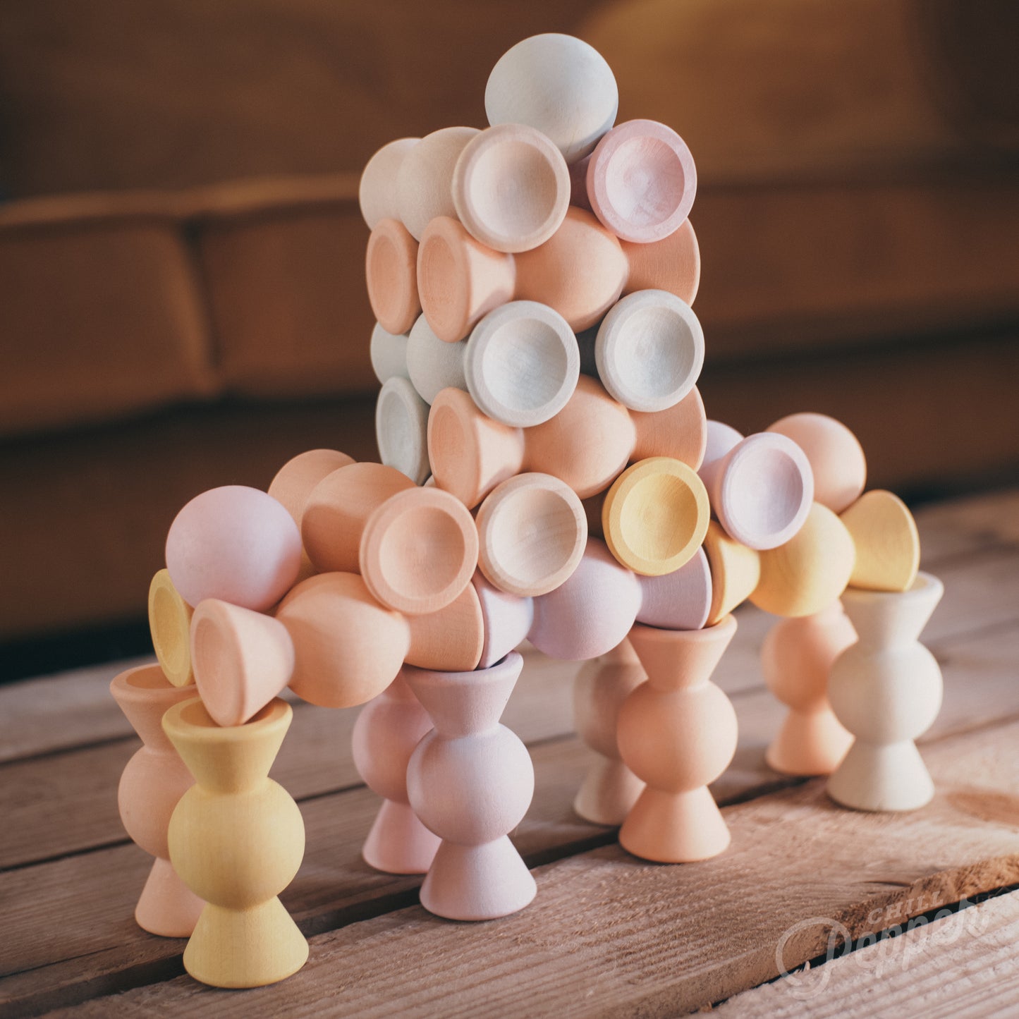 Wooden Chill Pepper Sweets stacking and spinning game for ages 3 and up, made from eco-friendly maple wood and non-toxic, water-based paints. The set includes 27 pastel-colored candy-shaped pieces and 6 gumballs for open-ended play.