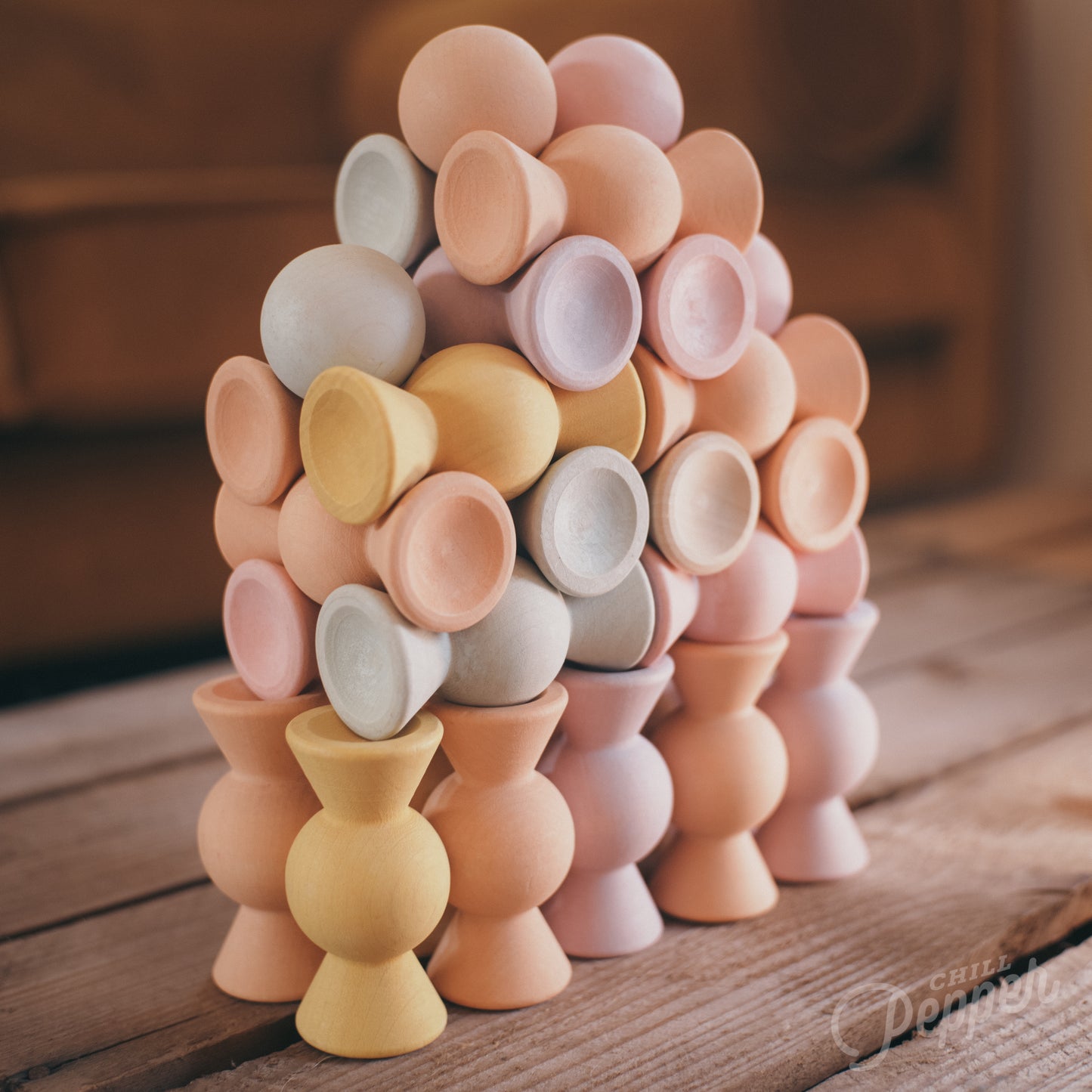 Wooden Chill Pepper Sweets stacking and spinning game for ages 3 and up, made from eco-friendly maple wood and non-toxic, water-based paints. The set includes 27 pastel-colored candy-shaped pieces and 6 gumballs for open-ended play.