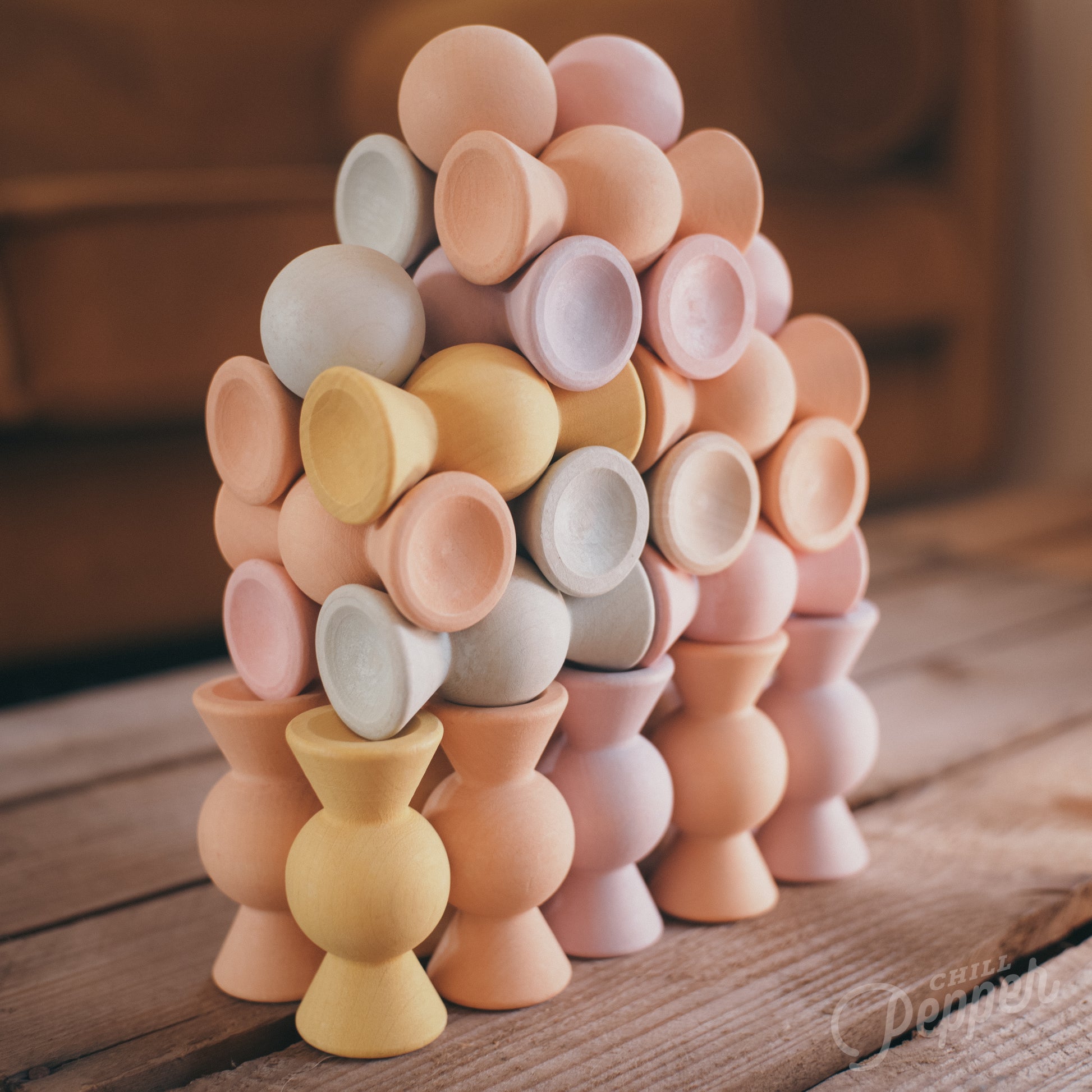 Wooden Chill Pepper Sweets stacking and spinning game for ages 3 and up, made from eco-friendly maple wood and non-toxic, water-based paints. The set includes 27 pastel-colored candy-shaped pieces and 6 gumballs for open-ended play.