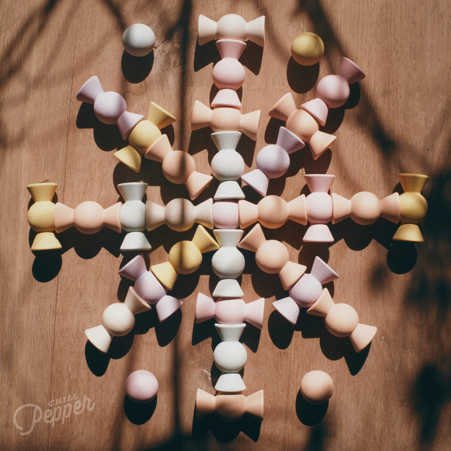 Wooden Chill Pepper Sweets stacking and spinning game for ages 3 and up, made from eco-friendly maple wood and non-toxic, water-based paints. The set includes 27 pastel-colored candy-shaped pieces and 6 gumballs for open-ended play.