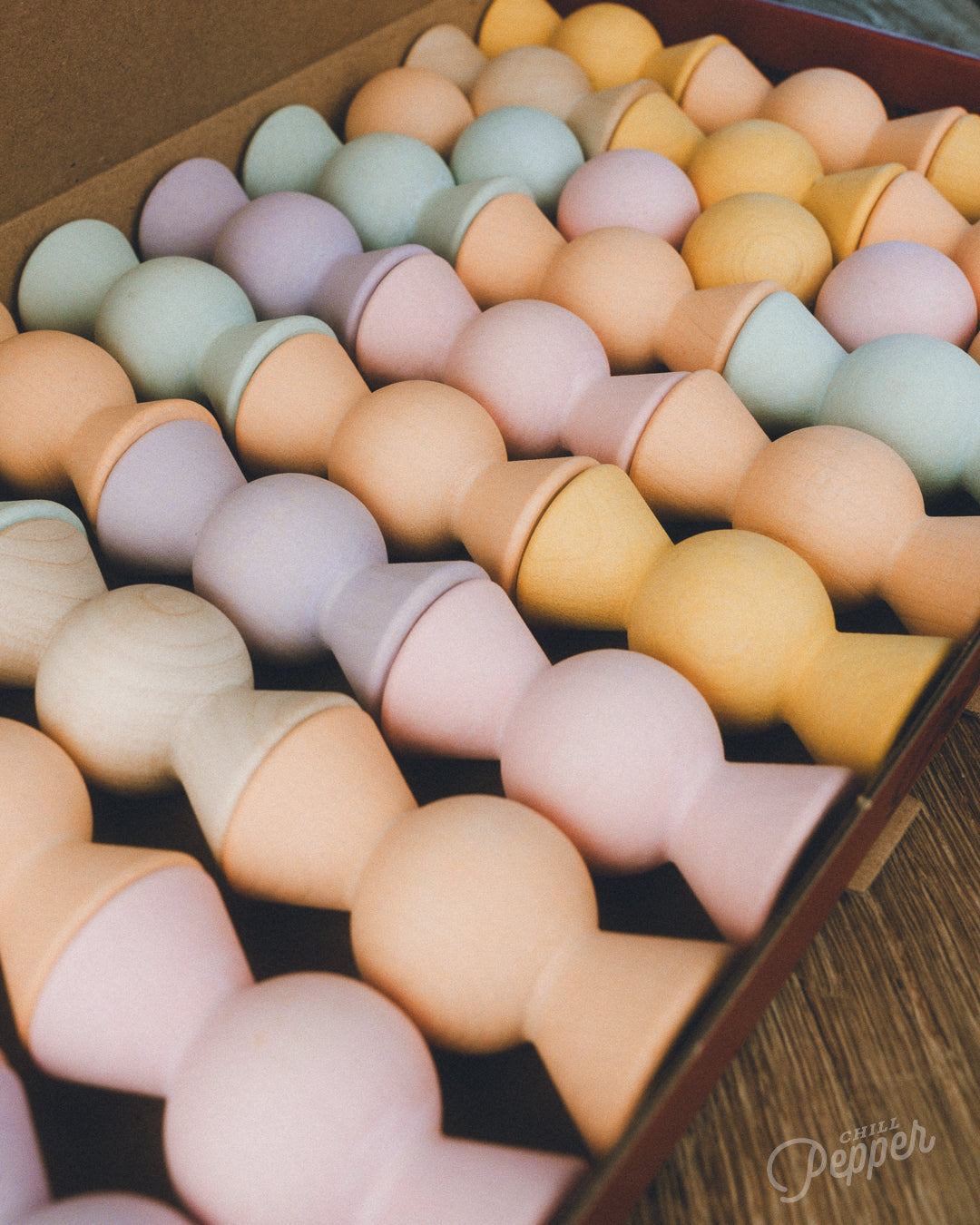 Wooden Chill Pepper Sweets stacking and spinning game for ages 3 and up, made from eco-friendly maple wood and non-toxic, water-based paints. The set includes 27 pastel-colored candy-shaped pieces and 6 gumballs for open-ended play.