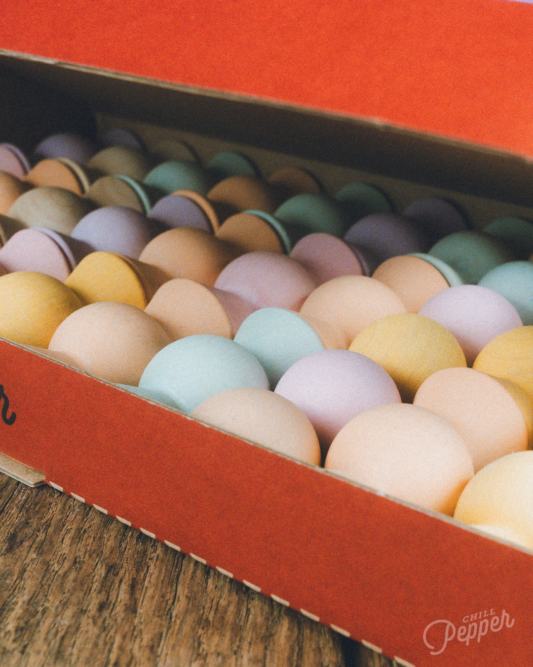 Wooden Chill Pepper Sweets stacking and spinning game for ages 3 and up, made from eco-friendly maple wood and non-toxic, water-based paints. The set includes 27 pastel-colored candy-shaped pieces and 6 gumballs for open-ended play.
