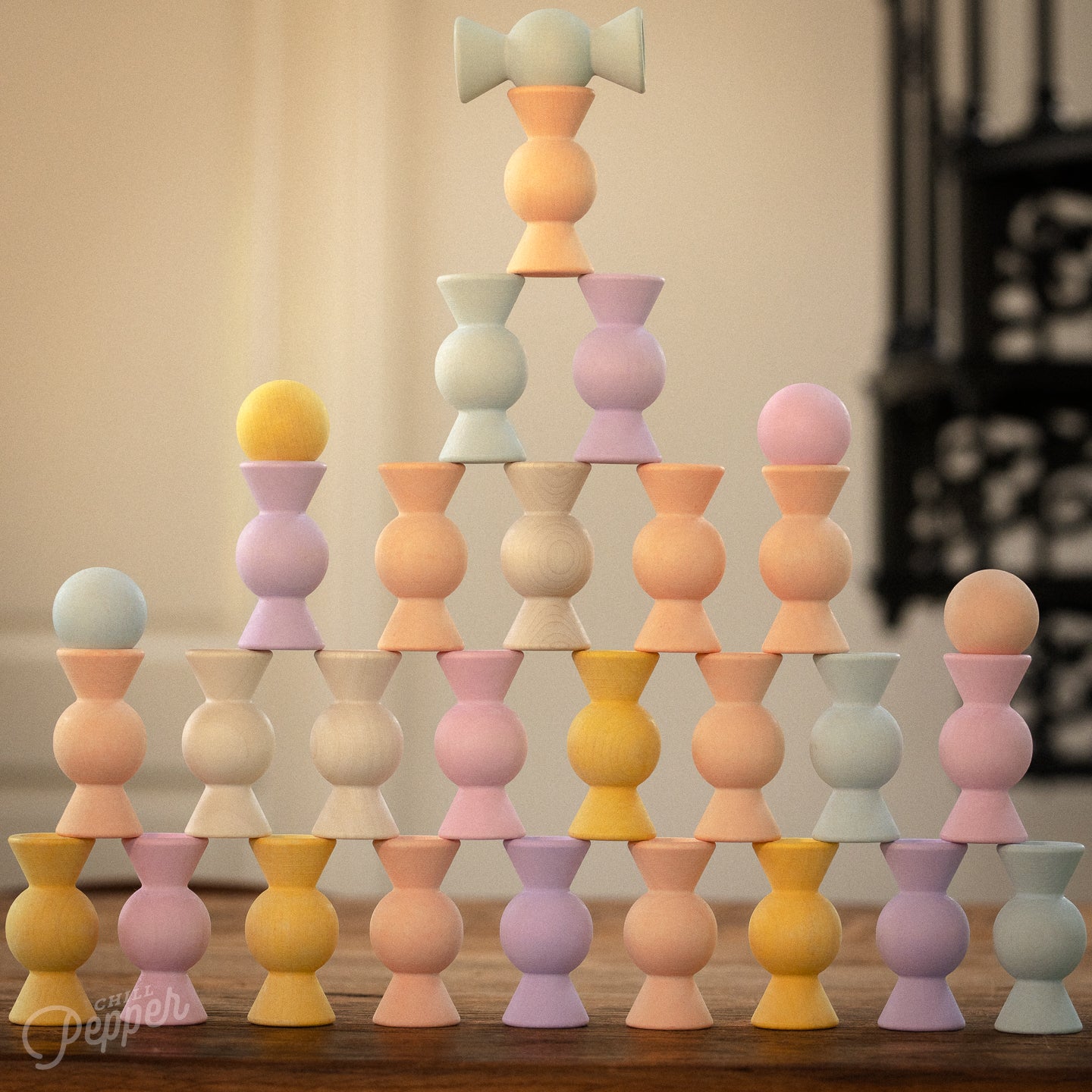 A stacked tower of Chill Pepper Sweets wooden toys in peachy pastel colors. Sustainable, made in Europe, open ended play.