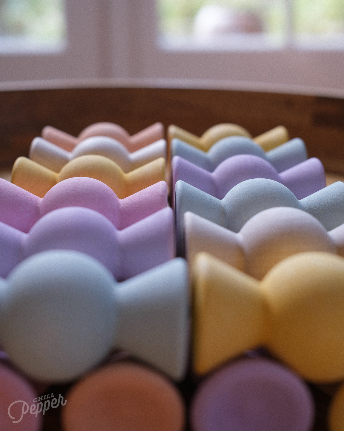 Chill Pepper Sweets Wooden Stacking game - organized in a row on a table with a blurred background