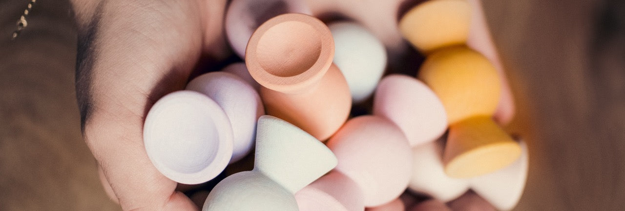 Hand held Chill Pepper Sweets close-up. A wooden stacking game made in Europe and resembles the shape of classic candy. Soft pastel colors and ready for open ended play