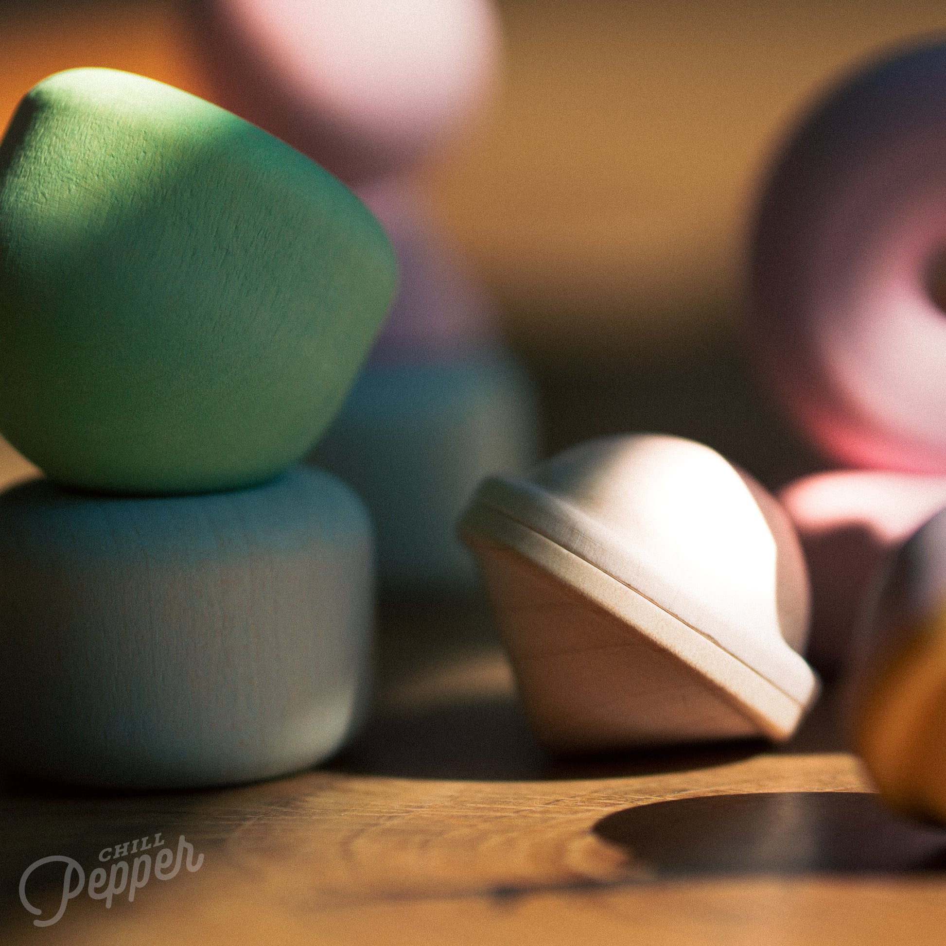 Wooden Chill Pepper Treats stacking and spinning game for ages 3 and up, made from eco-friendly maple wood and non-toxic, water-based paints. The set includes a variety of pastel-colored candy-shaped pieces and a unique Magic Egg for open-ended play.