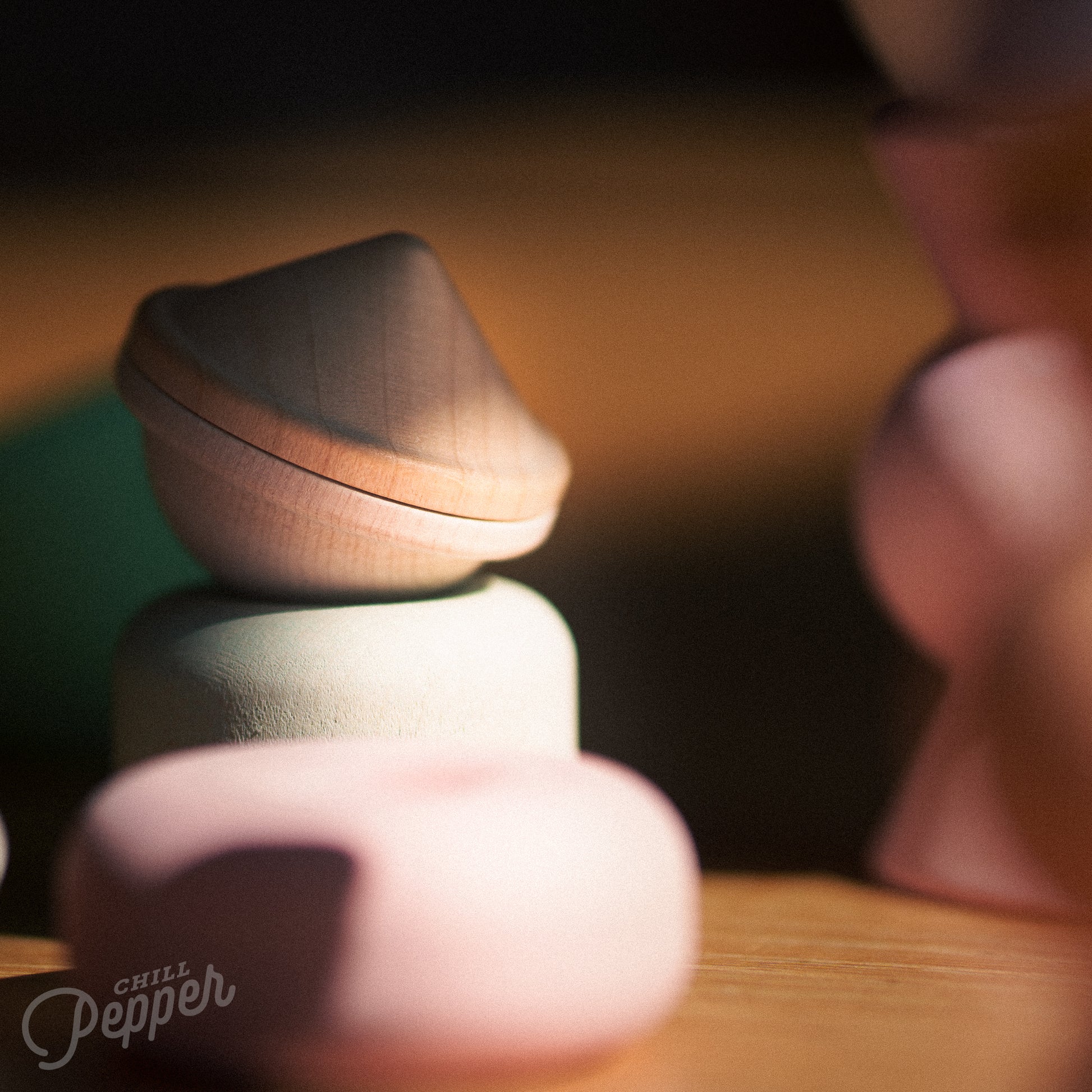 Wooden Chill Pepper Treats stacking and spinning game for ages 3 and up, made from eco-friendly maple wood and non-toxic, water-based paints. The set includes a variety of pastel-colored candy-shaped pieces and a unique Magic Egg for open-ended play.