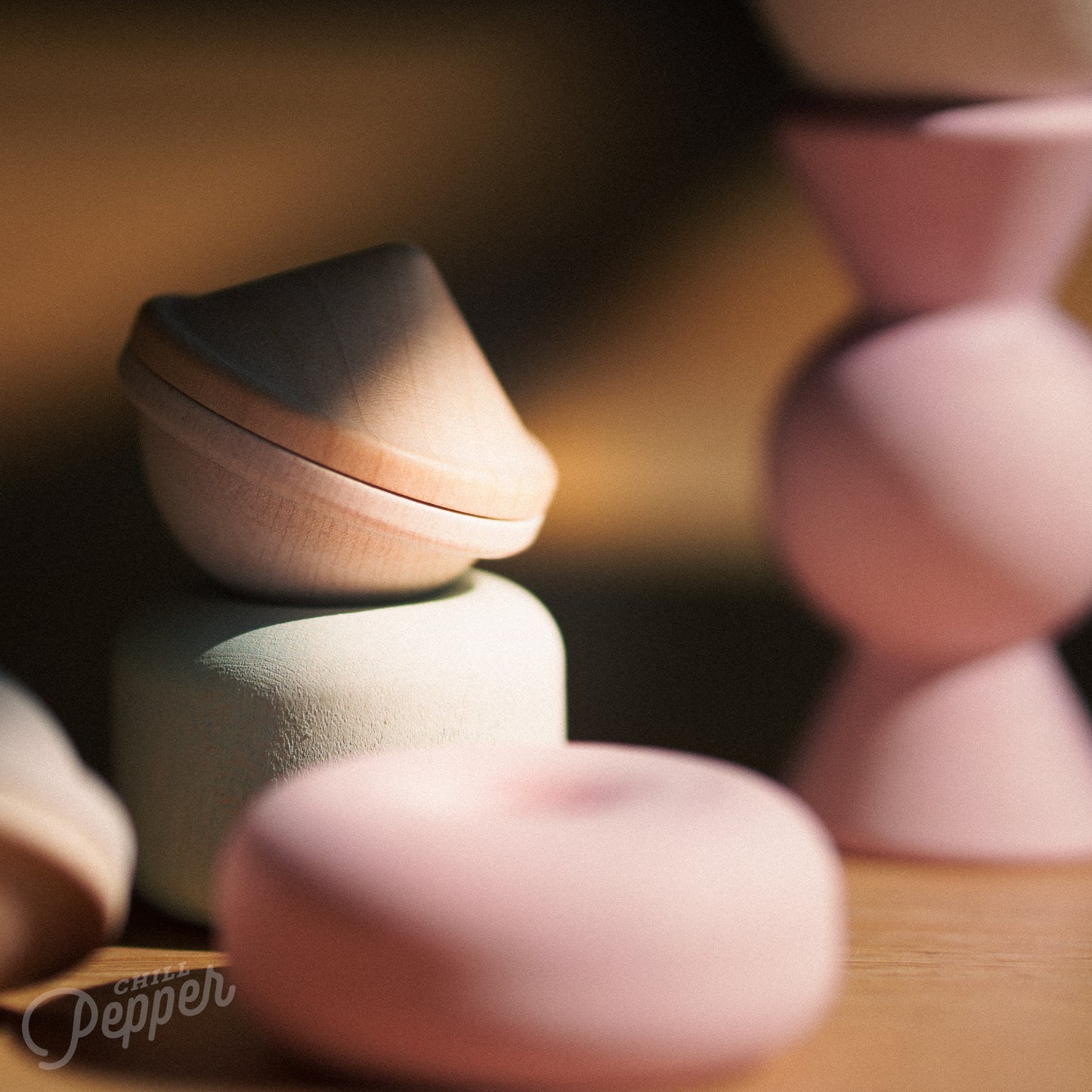 Wooden Chill Pepper Treats stacking and spinning game for ages 3 and up, made from eco-friendly maple wood and non-toxic, water-based paints. The set includes a variety of pastel-colored candy-shaped pieces and a unique Magic Egg for open-ended play.