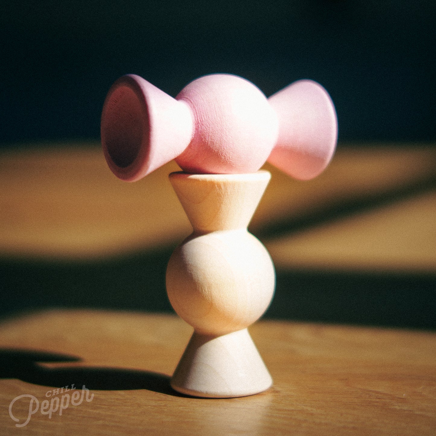 Wooden Chill Pepper Treats stacking and spinning game for ages 3 and up, made from eco-friendly maple wood and non-toxic, water-based paints. The set includes a variety of pastel-colored candy-shaped pieces and a unique Magic Egg for open-ended play.