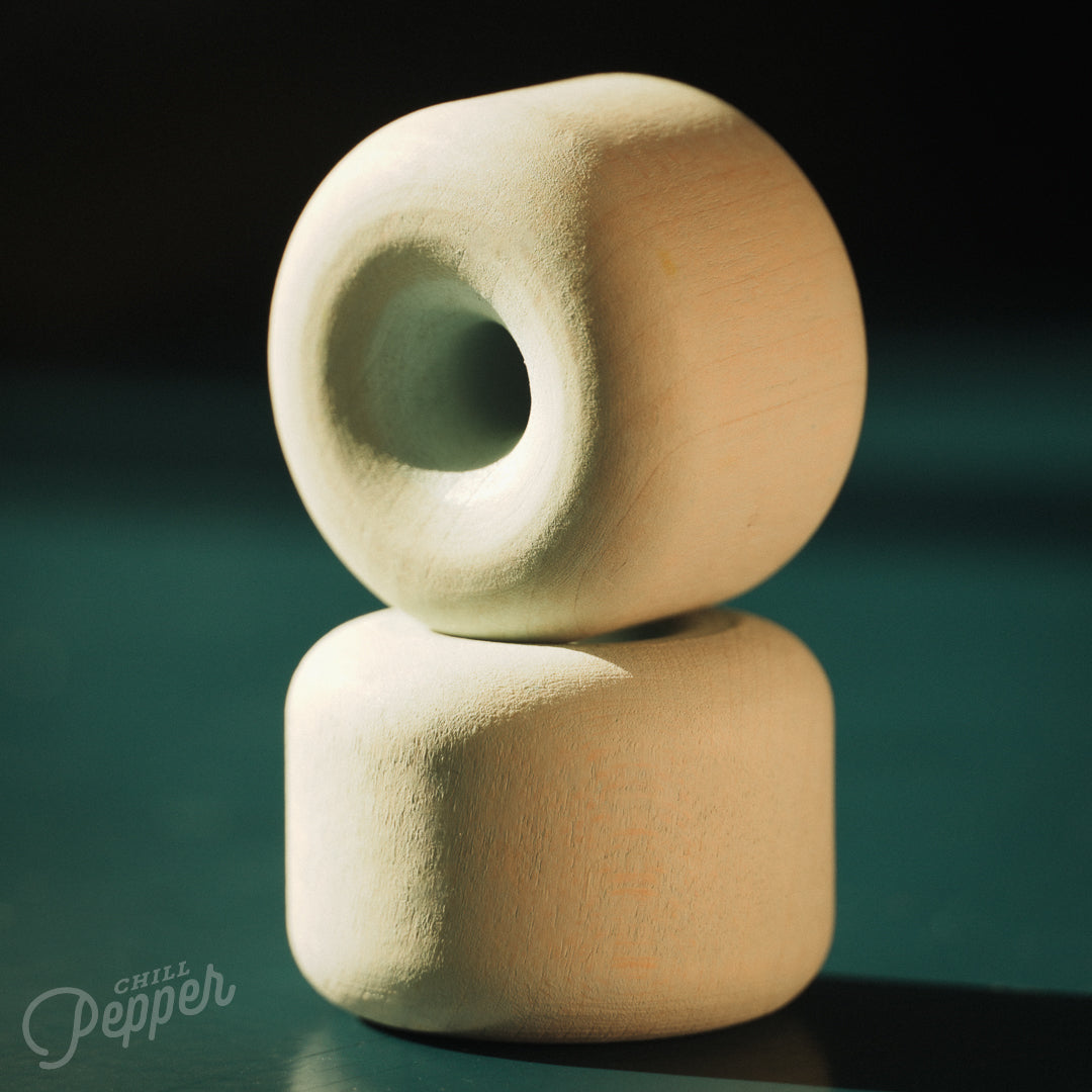 The two mint shaped pastel green Chill Pepper Treats – Wooden Stacking & Spinning Game stacked on top of each other. Made in Germany from sustainable Maple